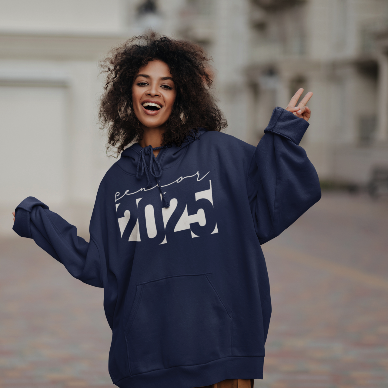 a woman with curly hair wearing a blue hoodie