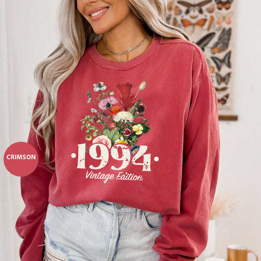 a woman wearing a red sweatshirt with flowers on it