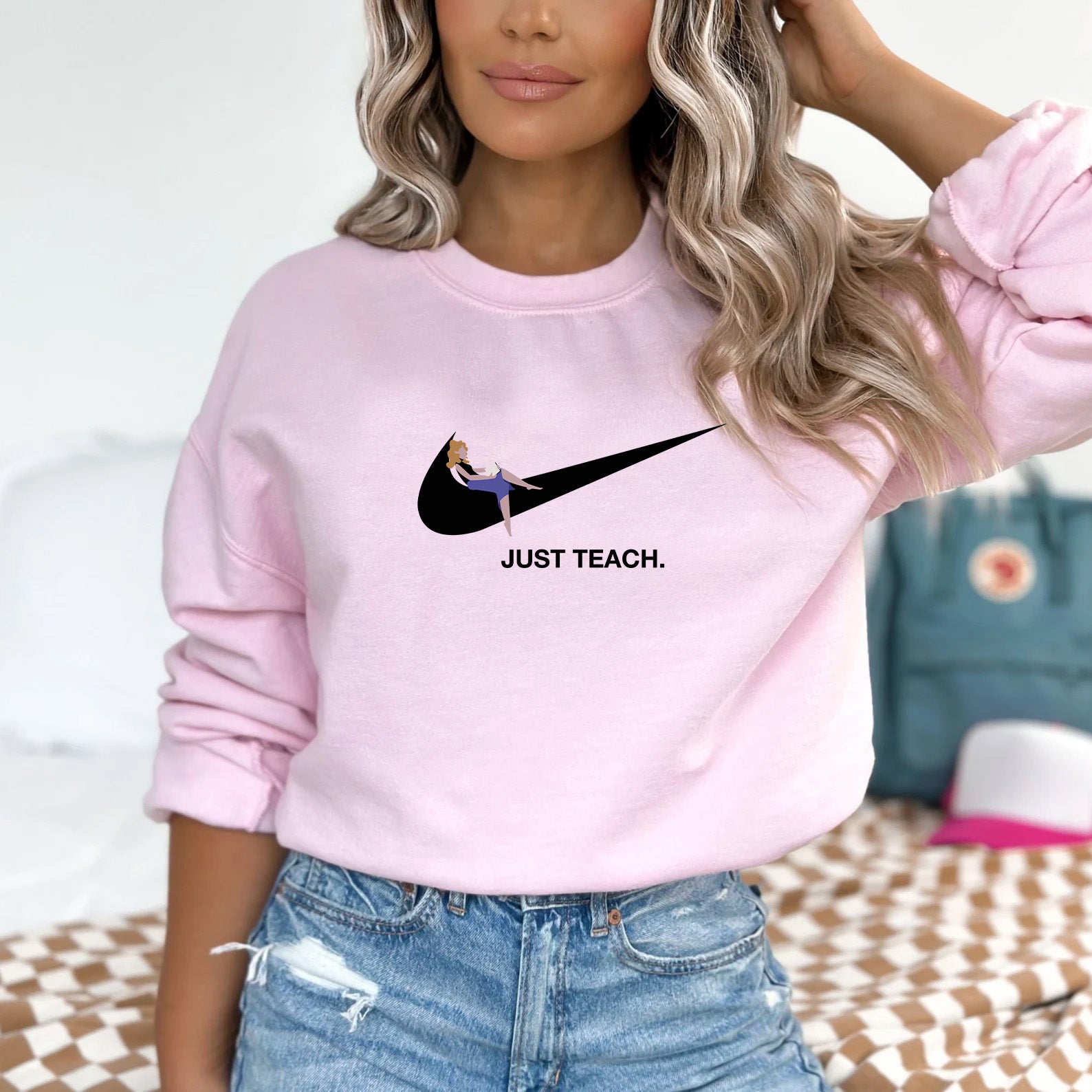 a woman wearing a pink nike sweatshirt with just teach on it