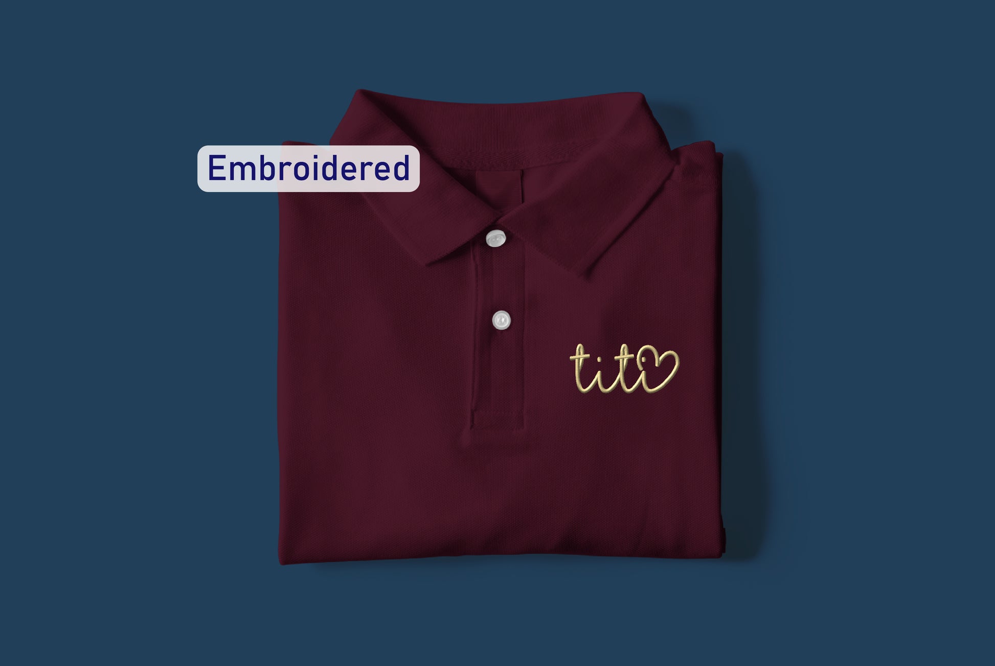 a maroon polo shirt with embroidered tis on it