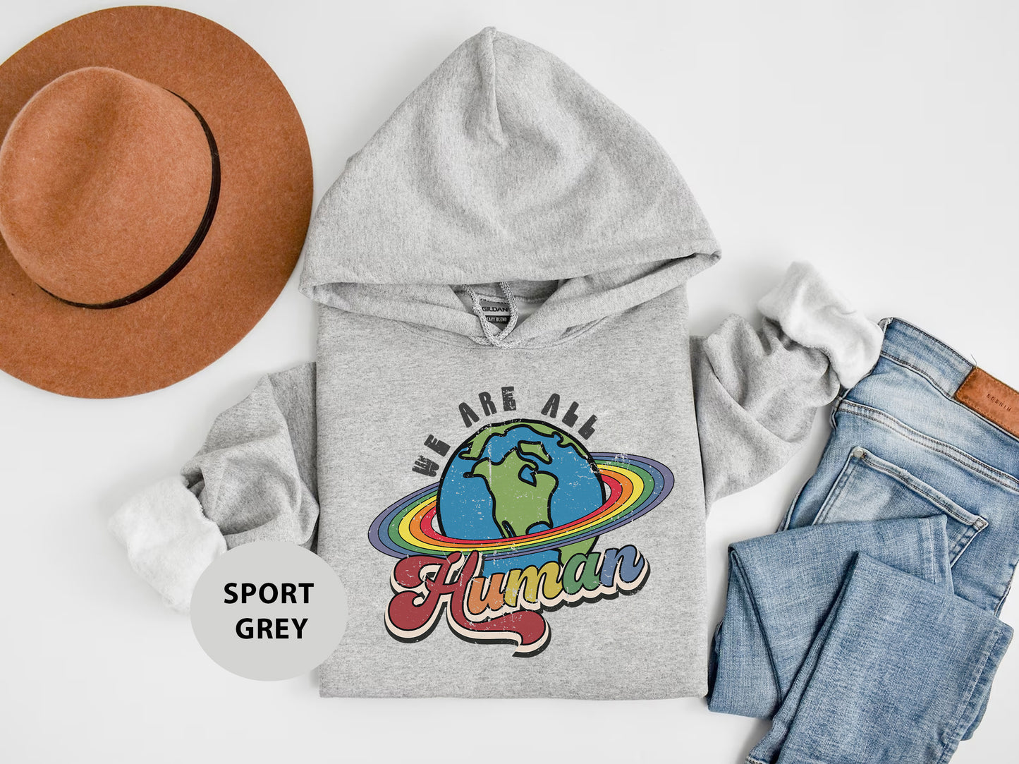 a hat, sweatshirt, jeans, and a pair of shoes on a white surface
