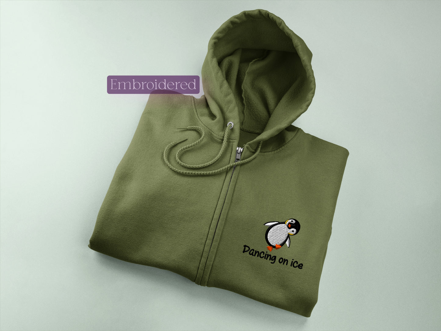 a green sweatshirt with a penguin embroidered on it