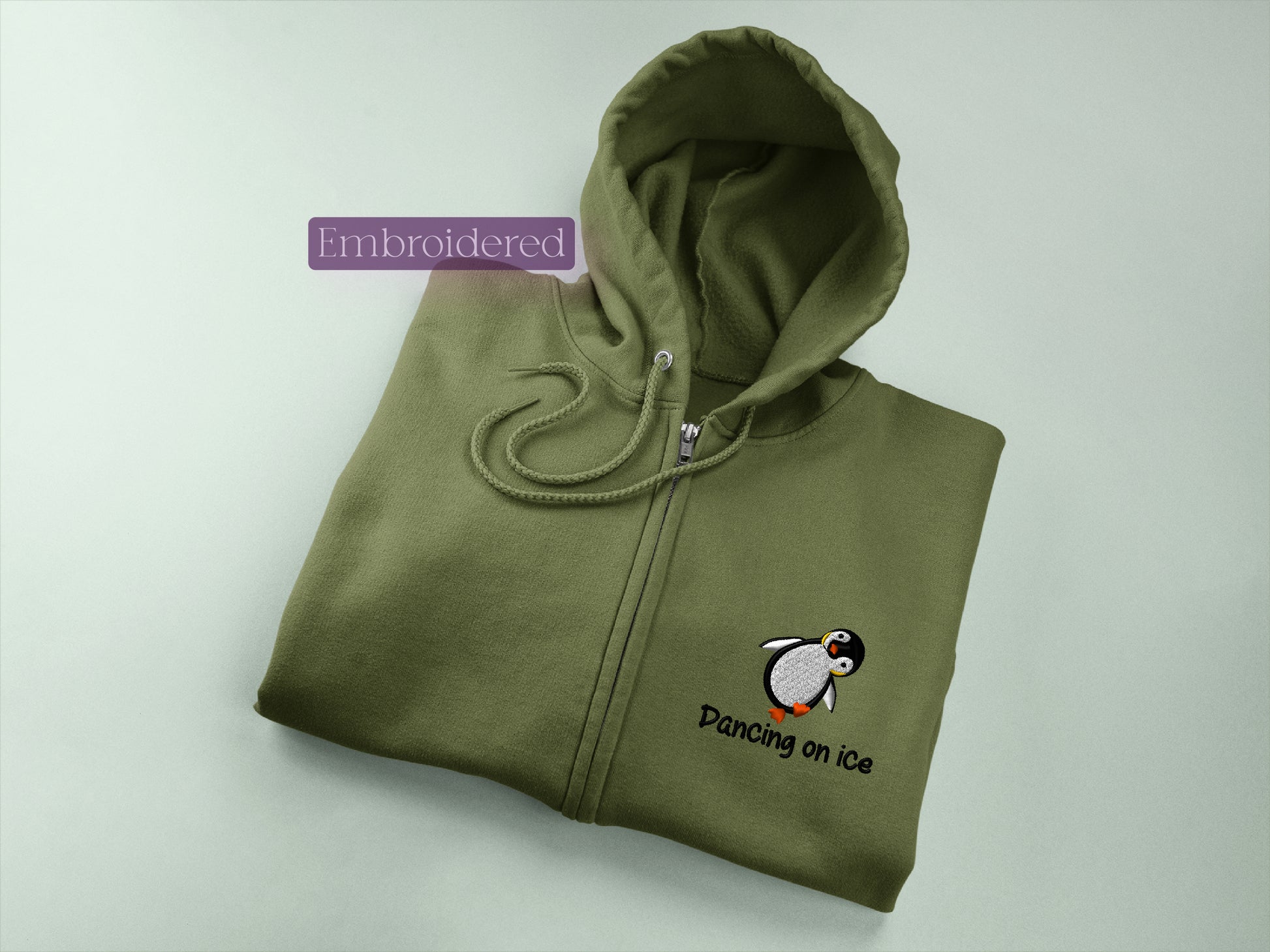 a green sweatshirt with a penguin embroidered on it