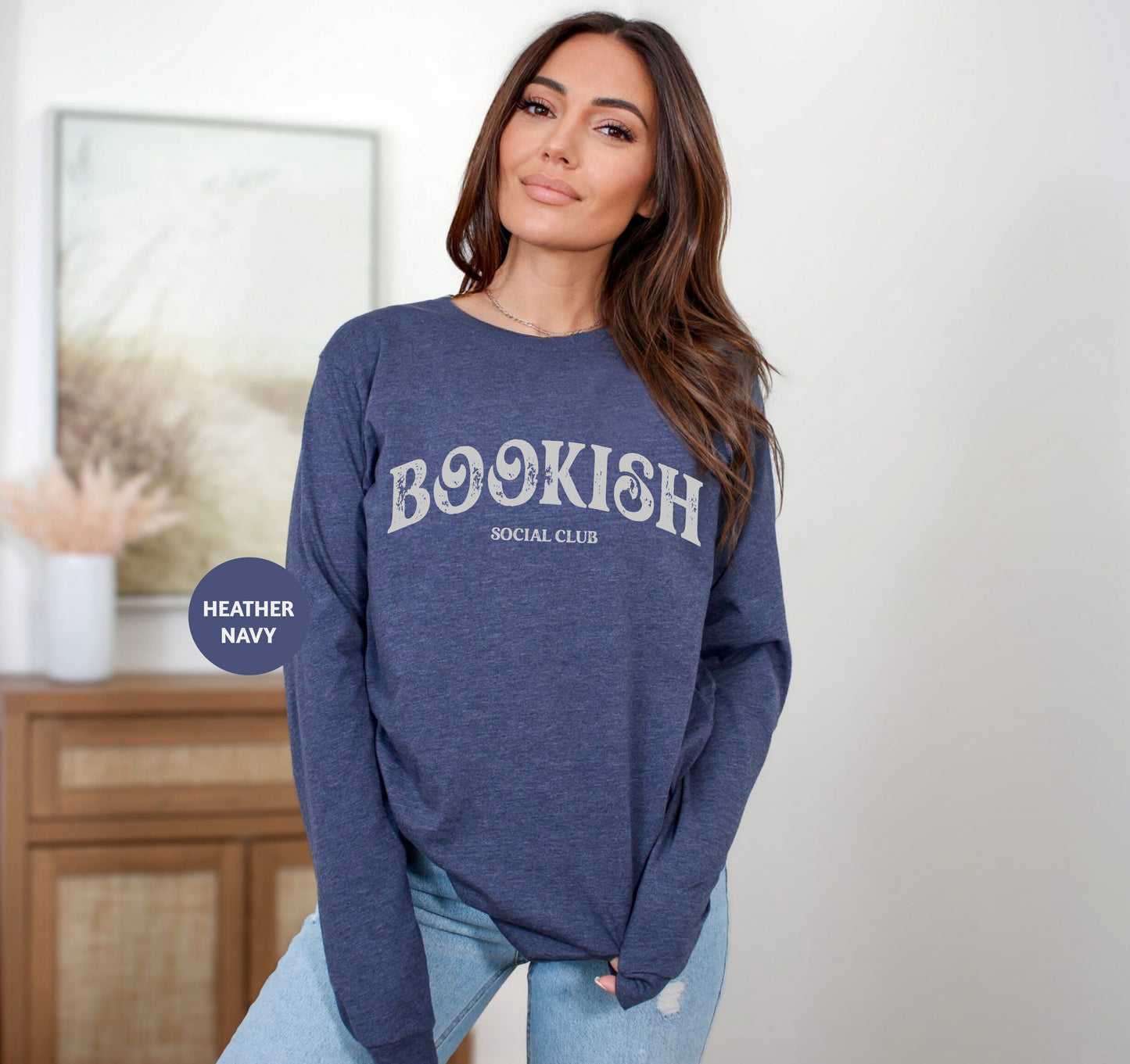 a woman standing in a room wearing a bookish sweatshirt