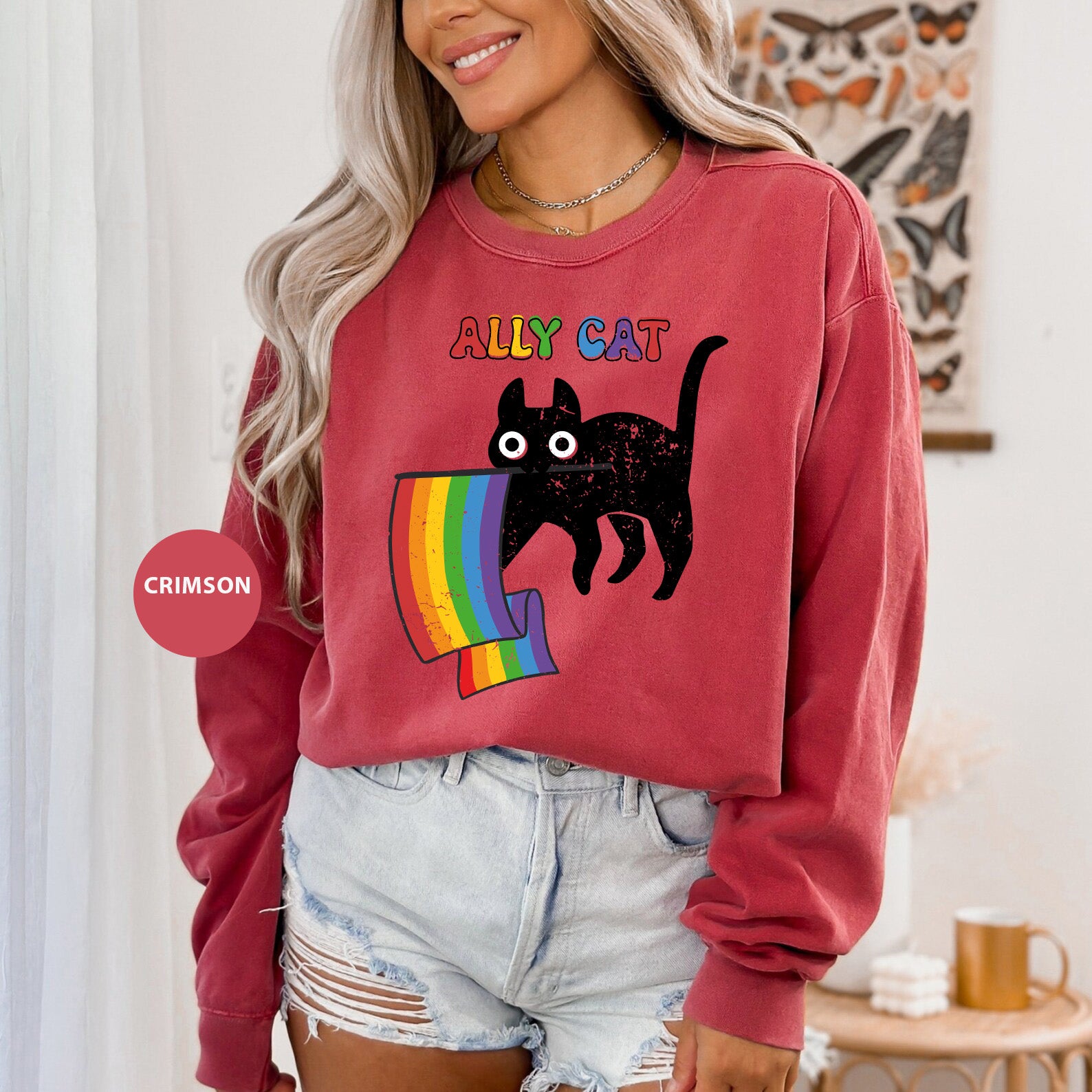 a woman wearing a red sweatshirt with a black cat on it