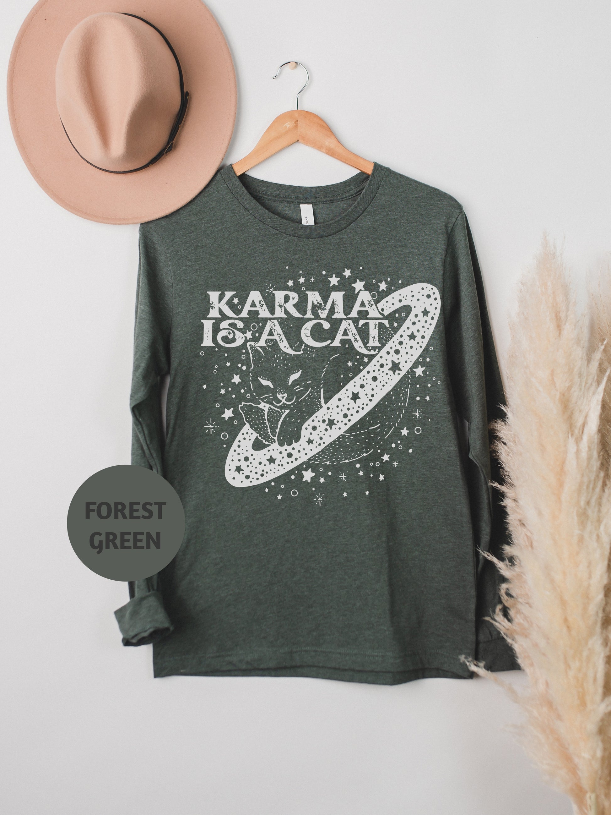 a t - shirt with a cat on it next to a hat