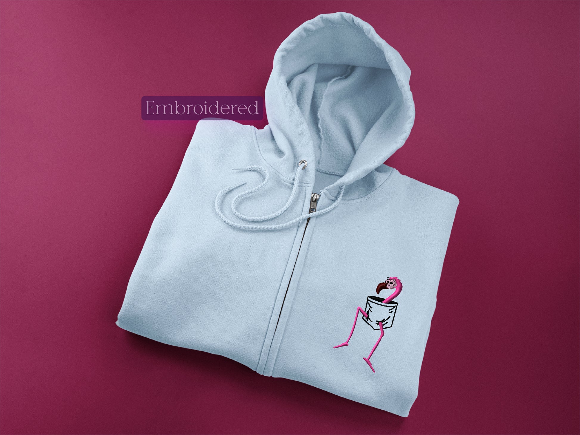 a white sweatshirt with a pink flamingo embroidered on it