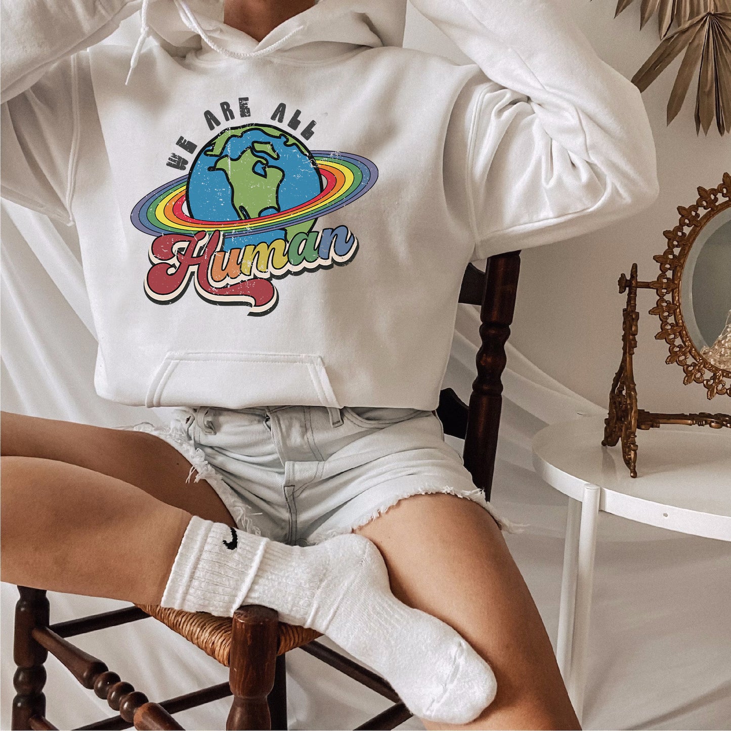 a woman sitting in a chair wearing a white hoodie