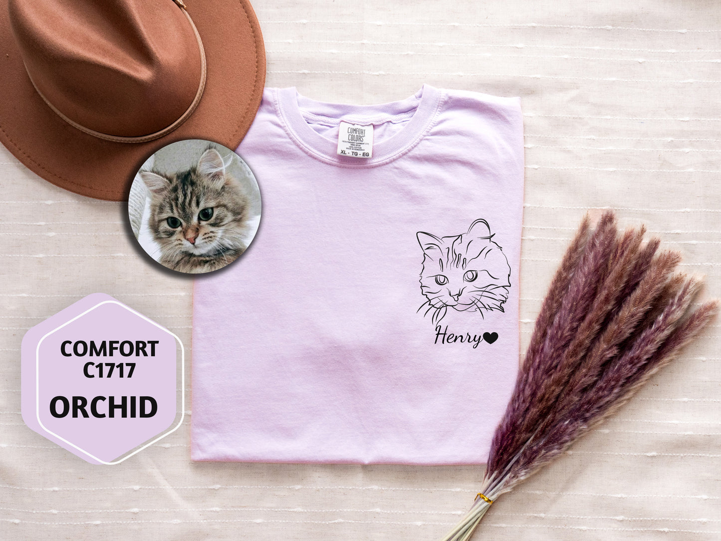 a t - shirt with a picture of a cat on it next to a hat