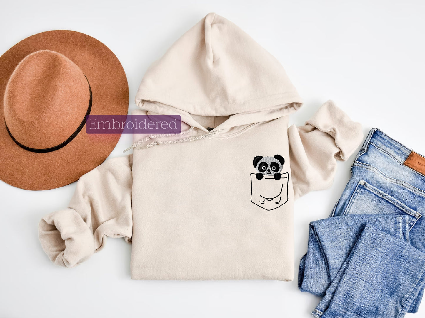 a hat, sweater, jeans, and a pair of shoes on a white surface