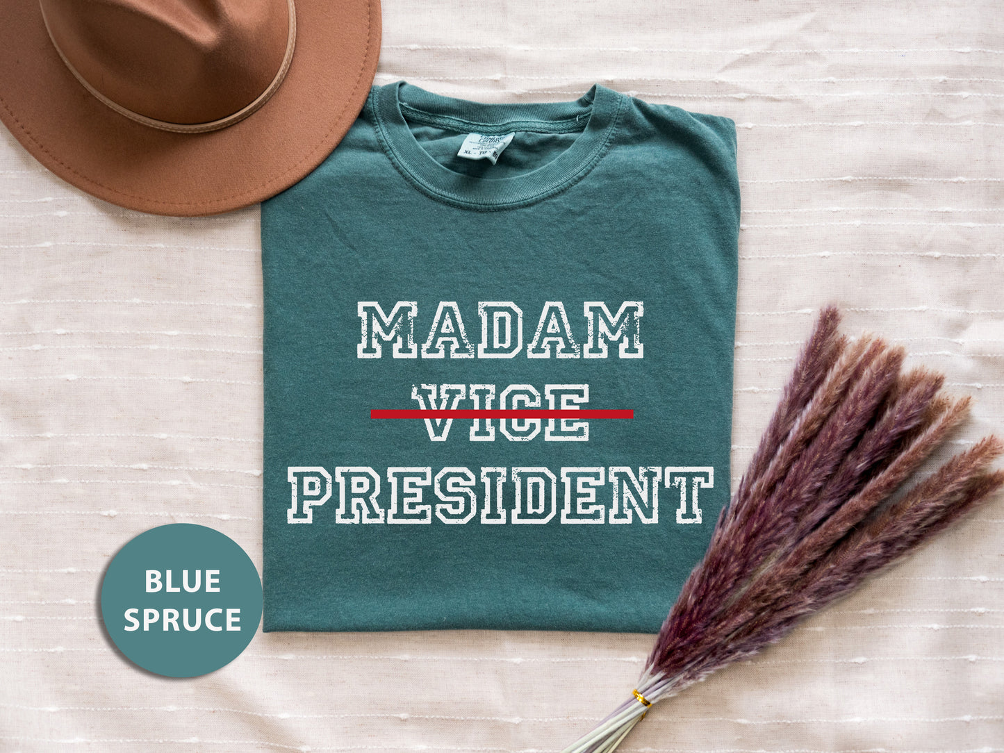 a t - shirt that says madam vice president next to a straw hat