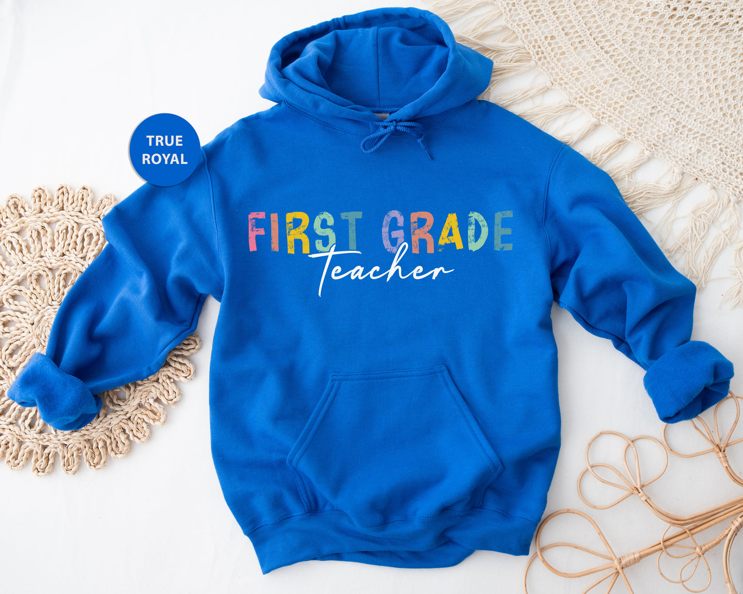a blue sweatshirt with the words first grade teacher on it