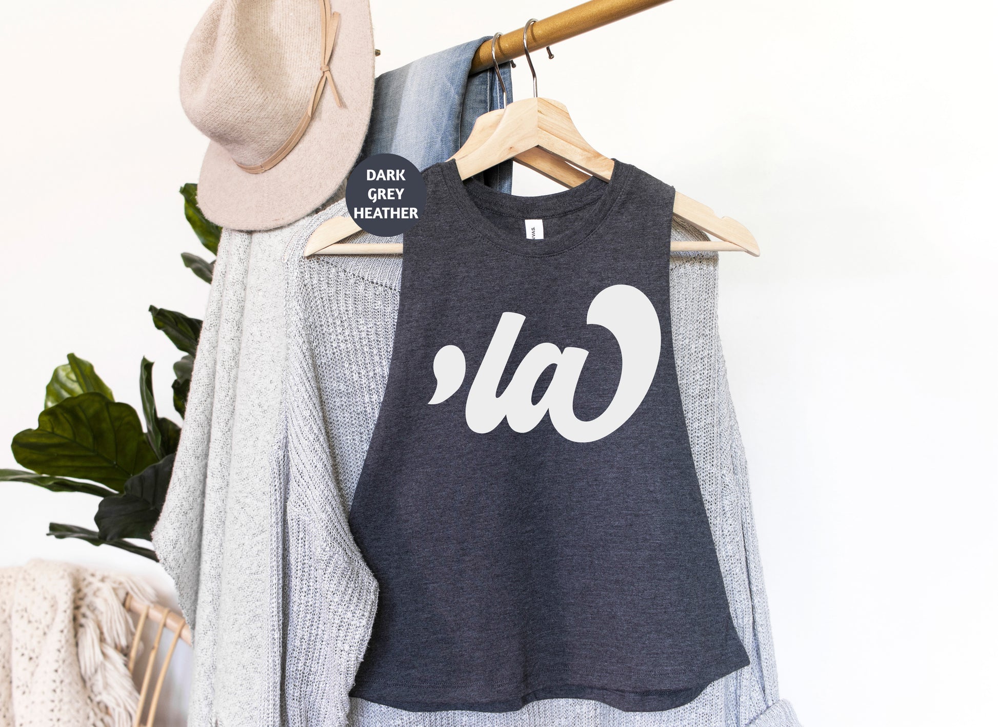 a t - shirt hanging on a clothes rack with a hat on it