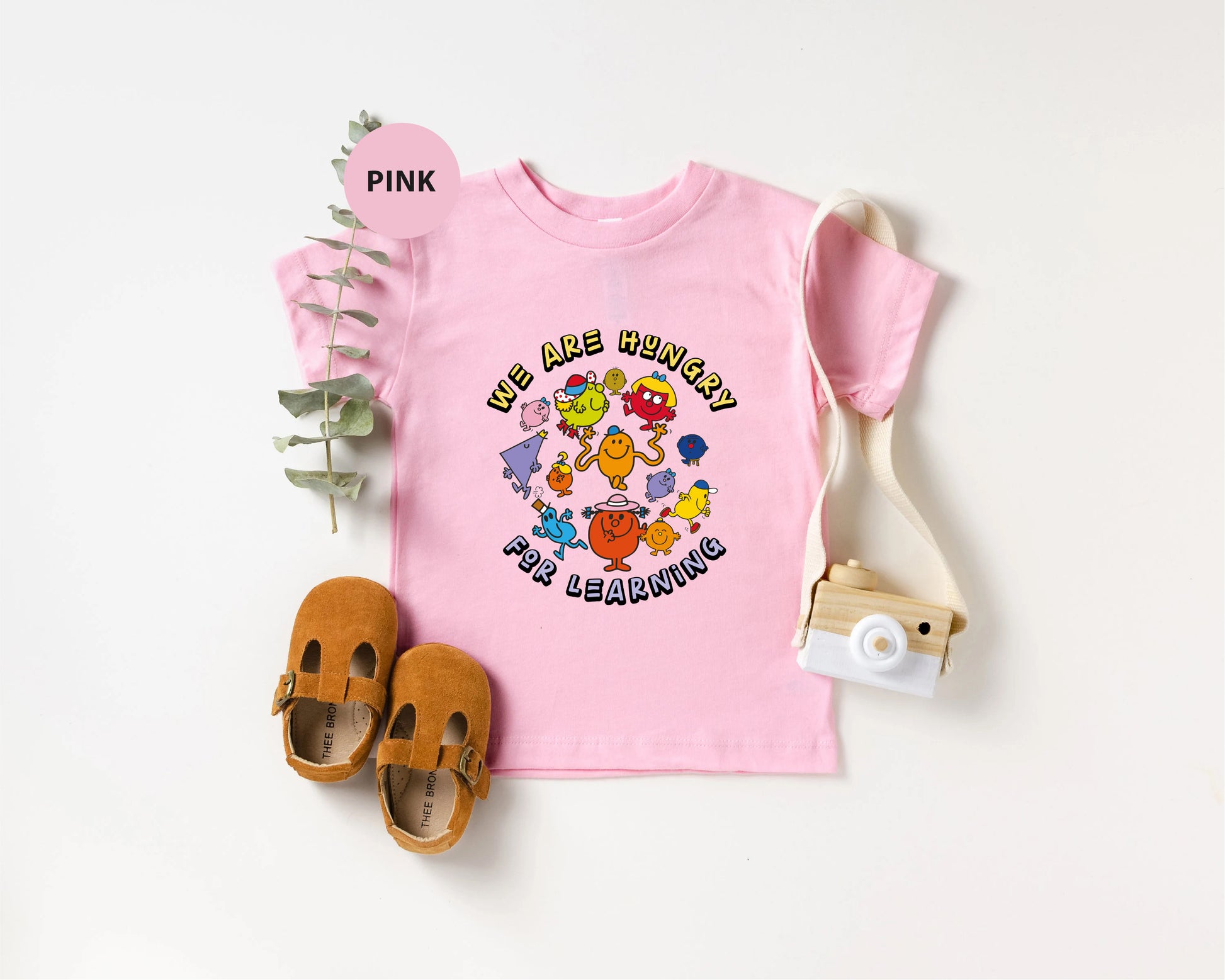 a pink t - shirt with the words pink on it next to a pair of