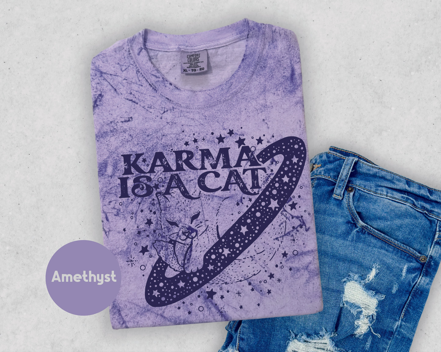 a t - shirt that says karma is a cat next to a pair of jeans