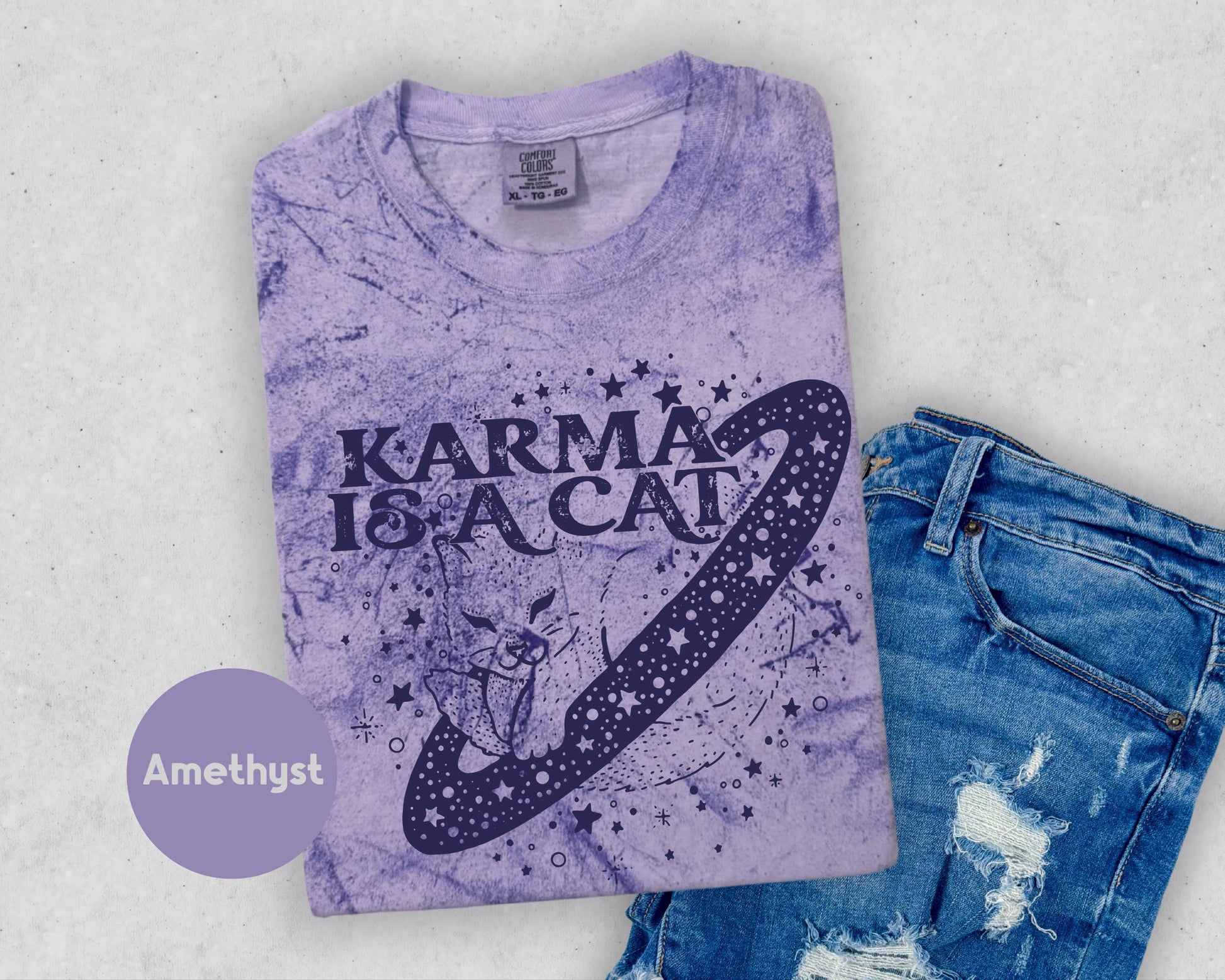a t - shirt that says karma is a cat next to a pair of jeans