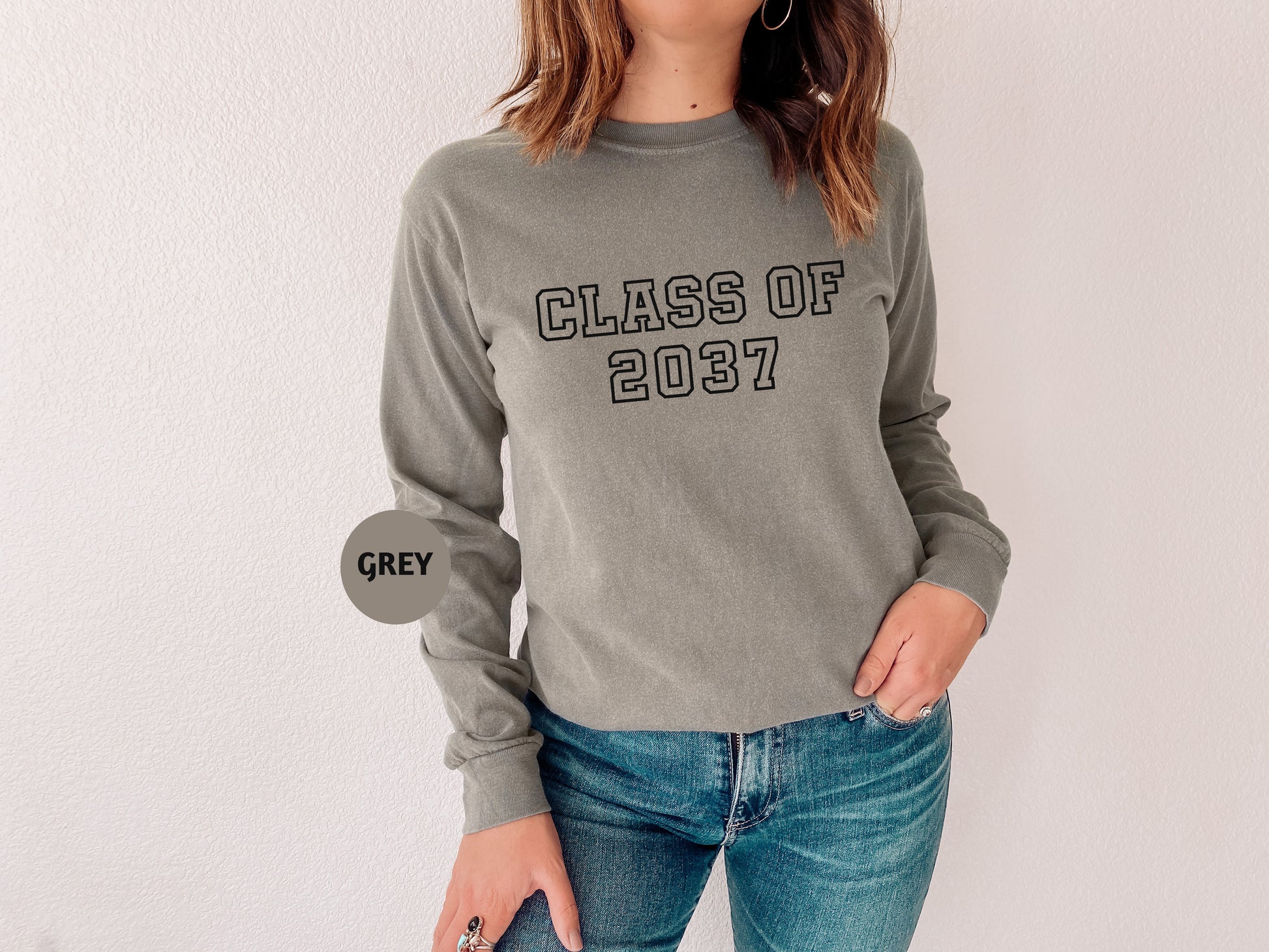 a woman wearing a gray sweatshirt with the words class of 2017 printed on it