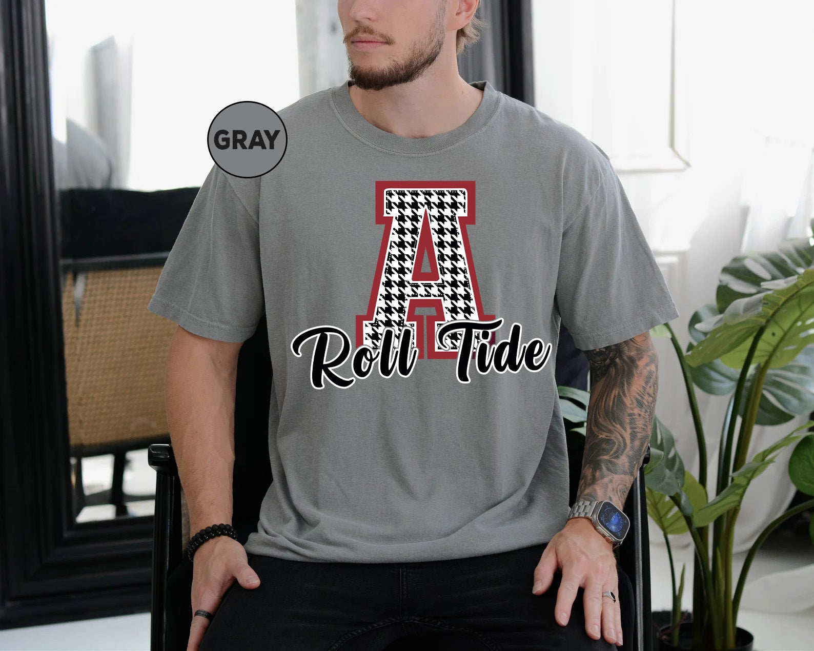 a man sitting in a chair wearing a gray t - shirt