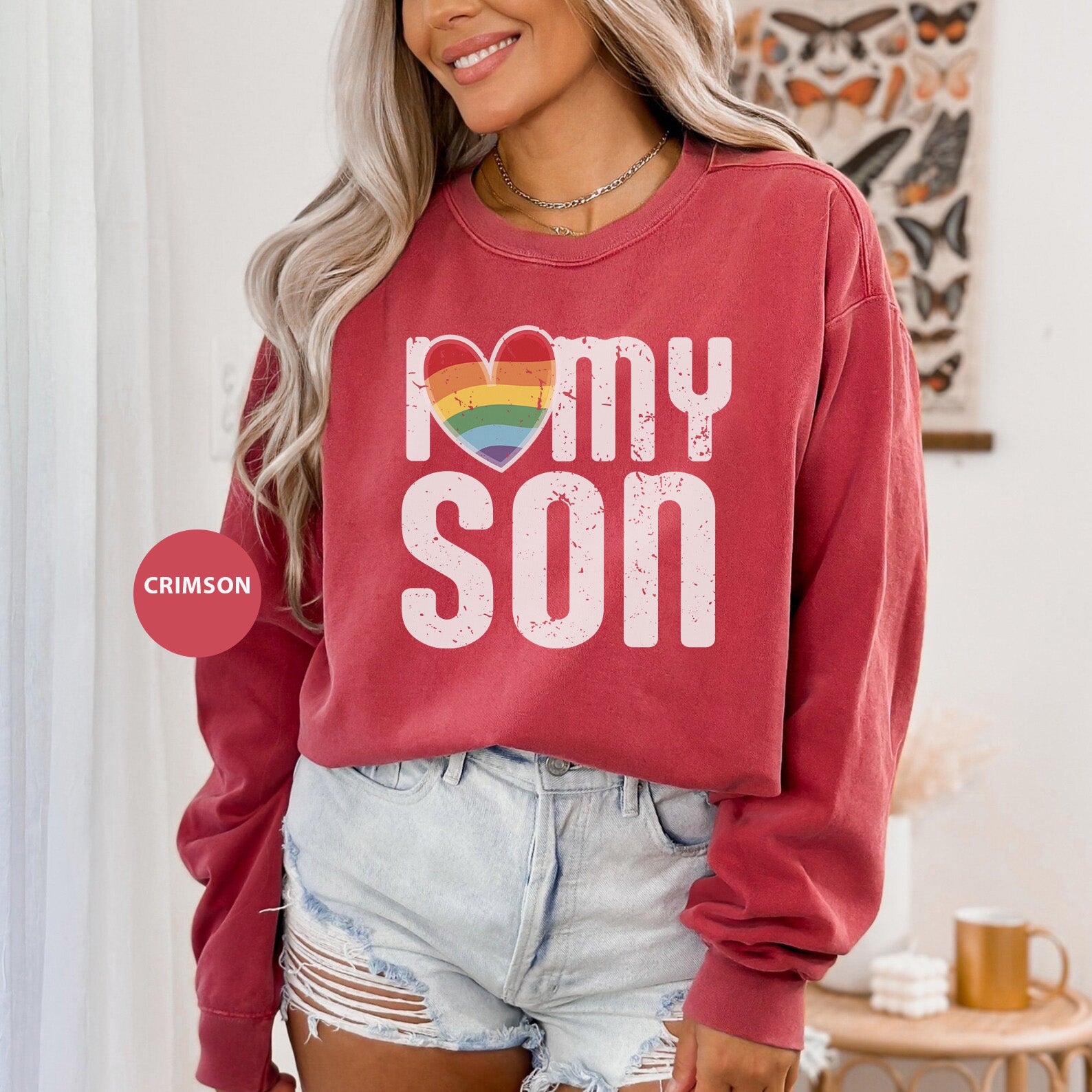 a woman wearing a red sweatshirt that says i love my son