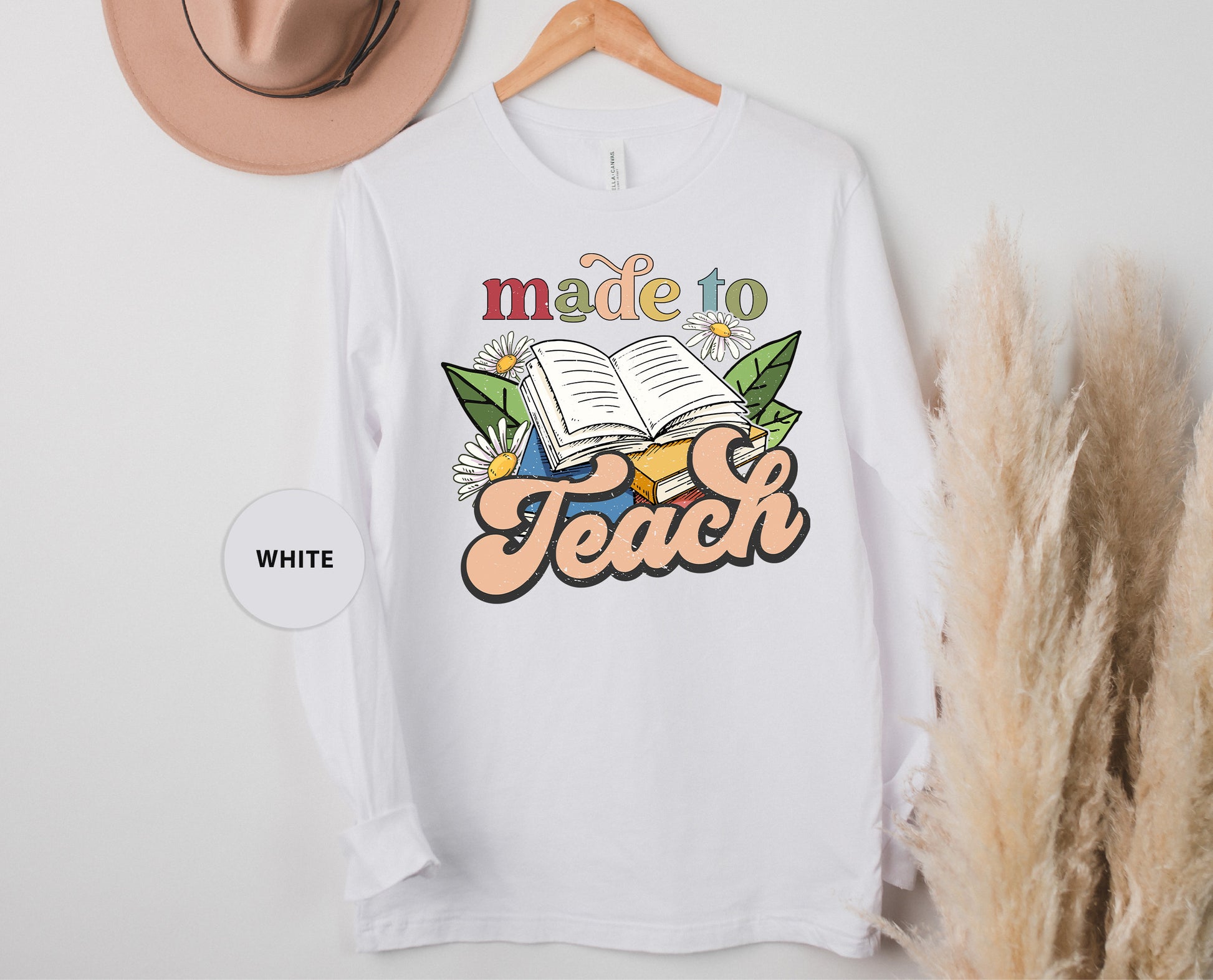 a white t - shirt with a book and a hat next to it