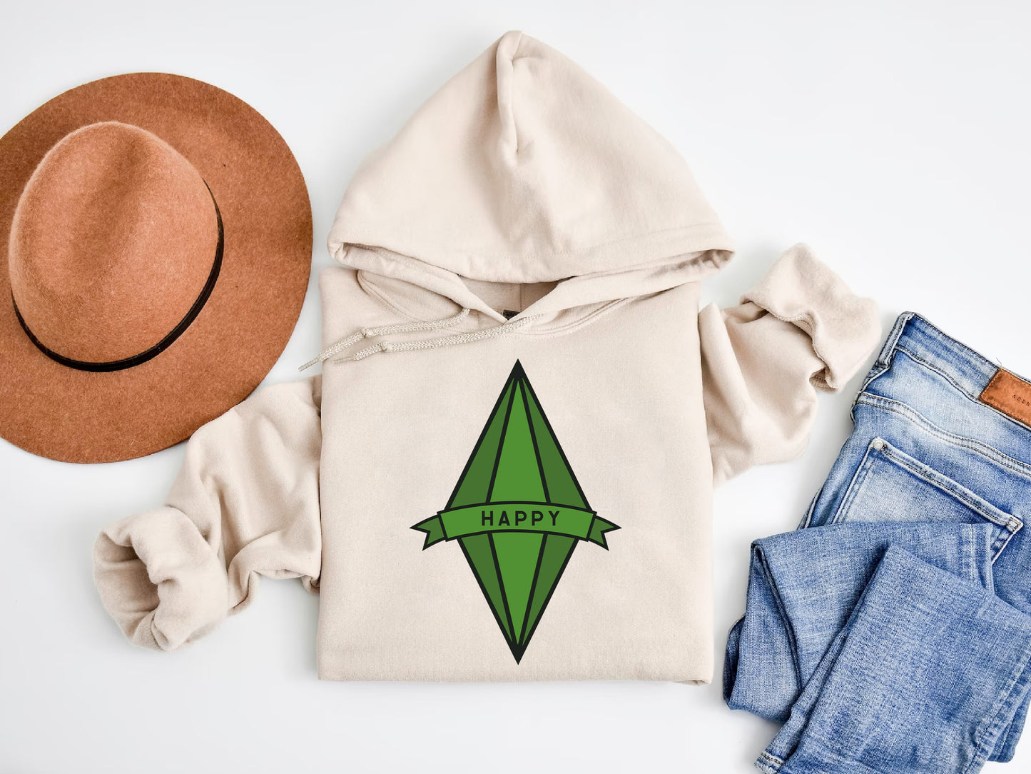 a hat, sweatshirt, jeans, and a pair of shoes on a white surface