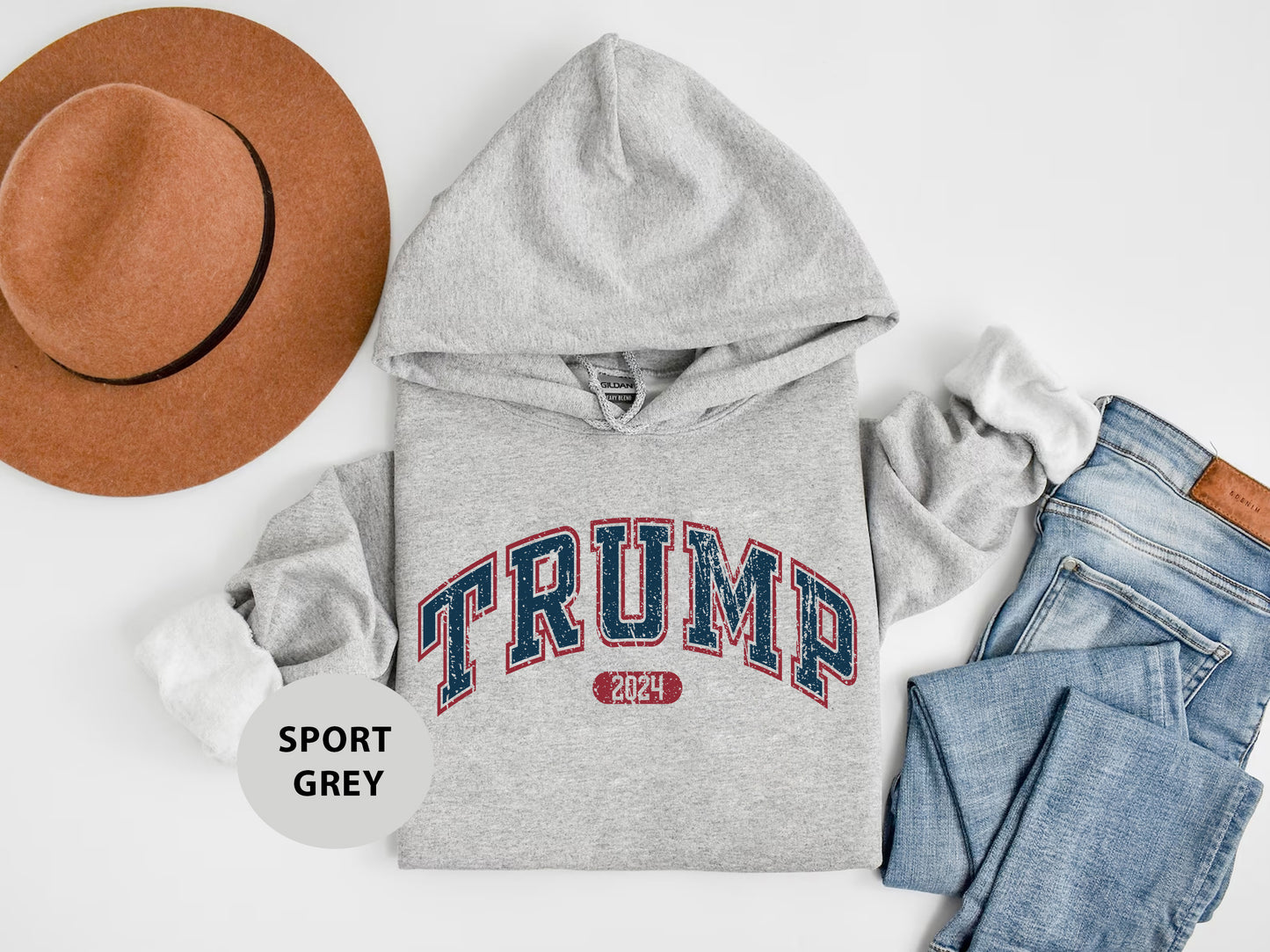 a hat, sweatshirt, jeans, and a pair of shoes on a white surface