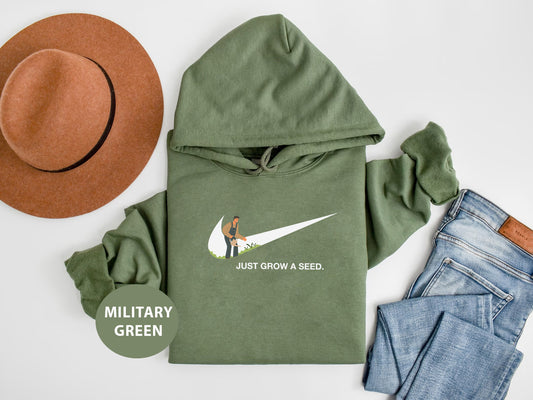 a military green hoodie with a hat and jeans