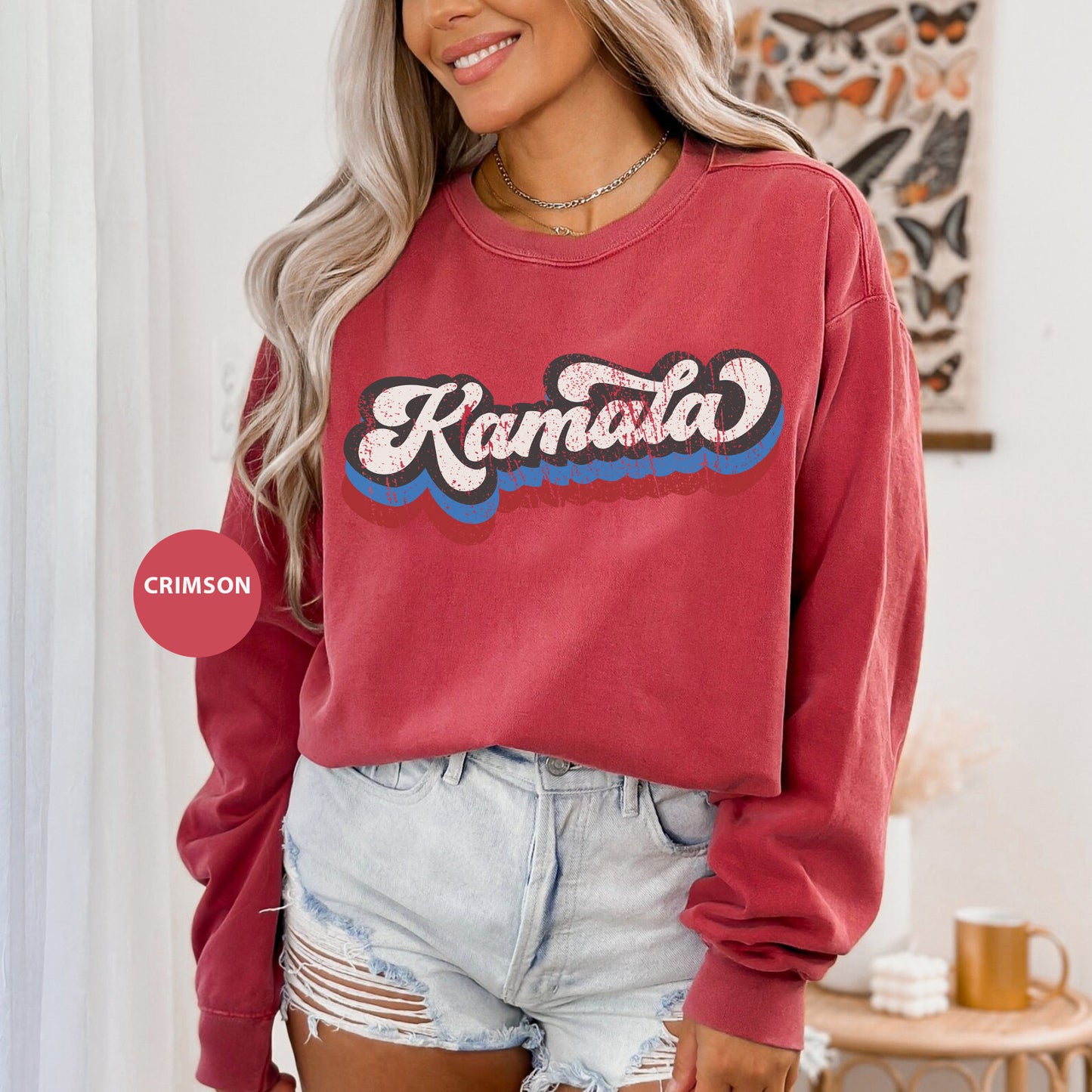 a woman wearing a red sweatshirt and denim shorts