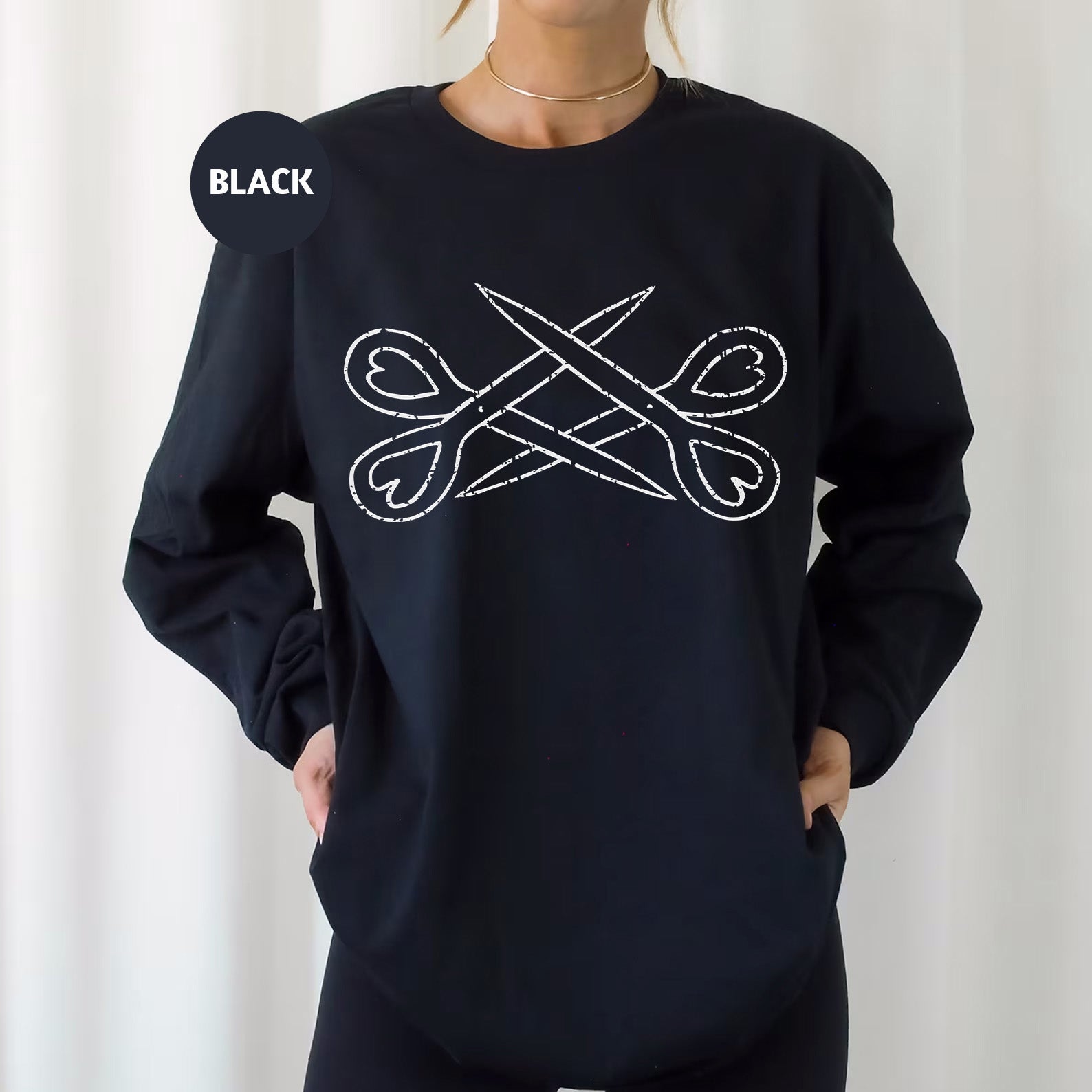 a woman wearing a black sweatshirt with scissors on it