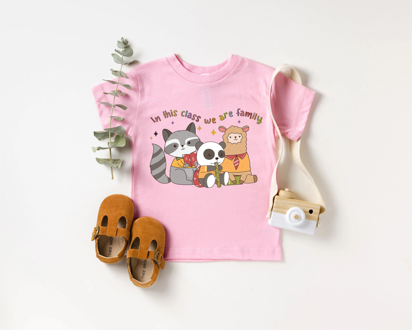 a pink shirt with a raccoon and panda on it