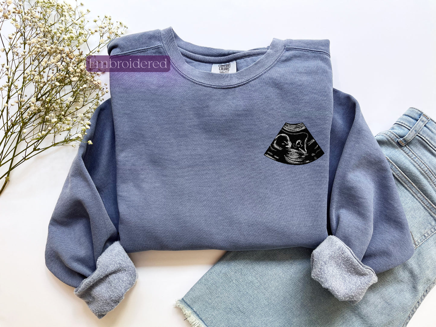 a blue sweatshirt with a black cat on it
