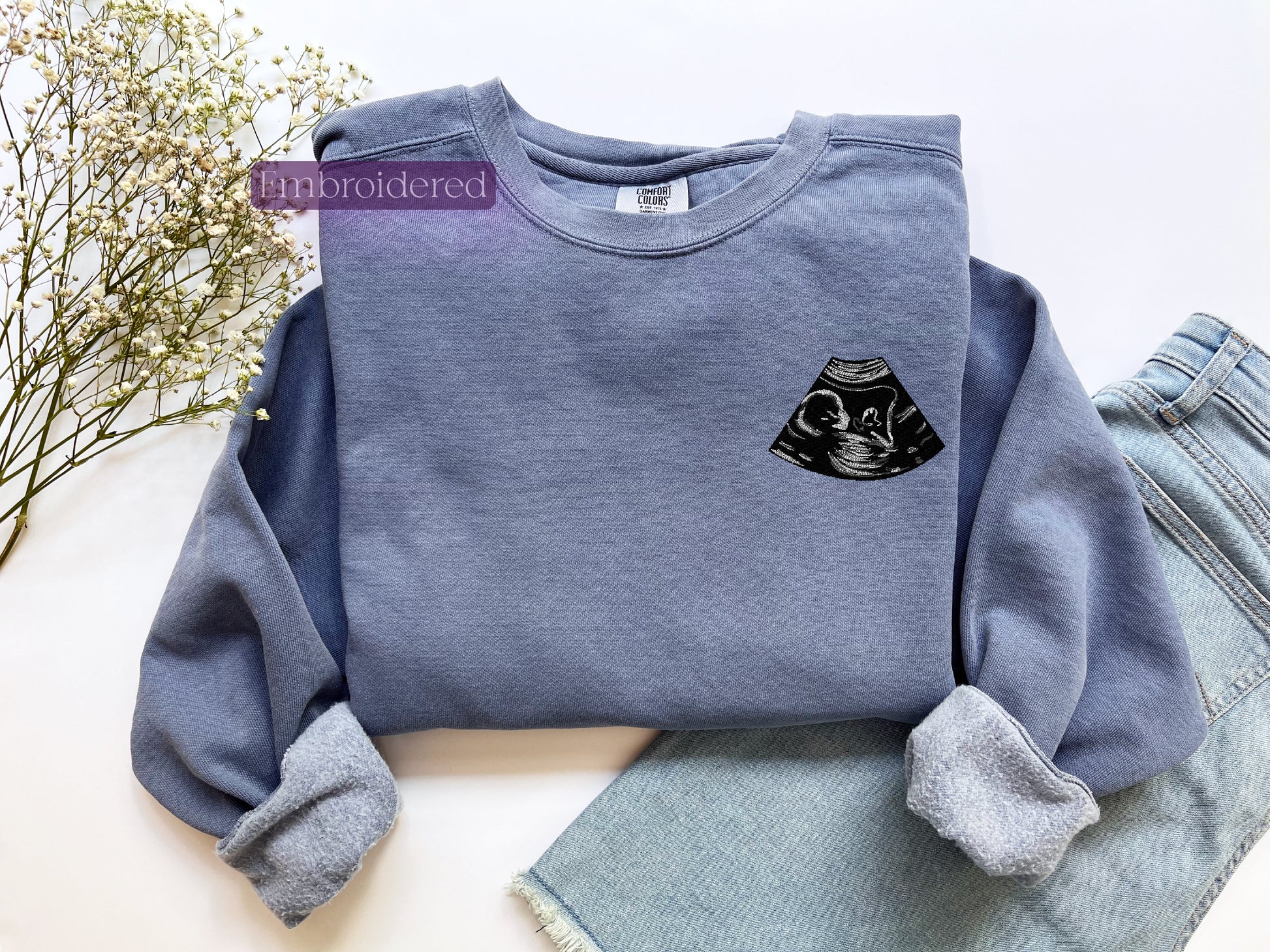 a blue sweatshirt with a black cat on it