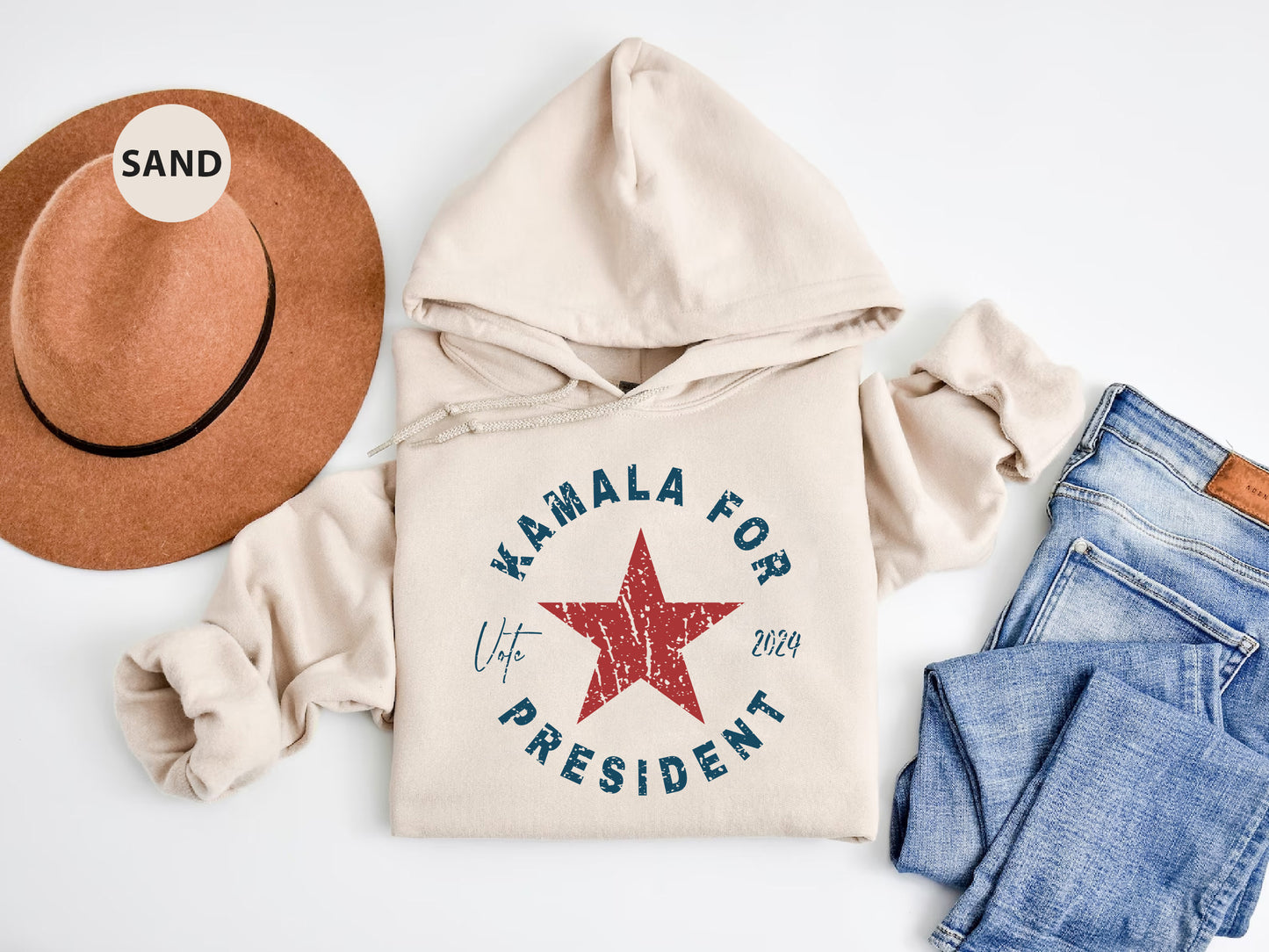 a hat, sweatshirt, jeans, and a pair of shoes on a white surface