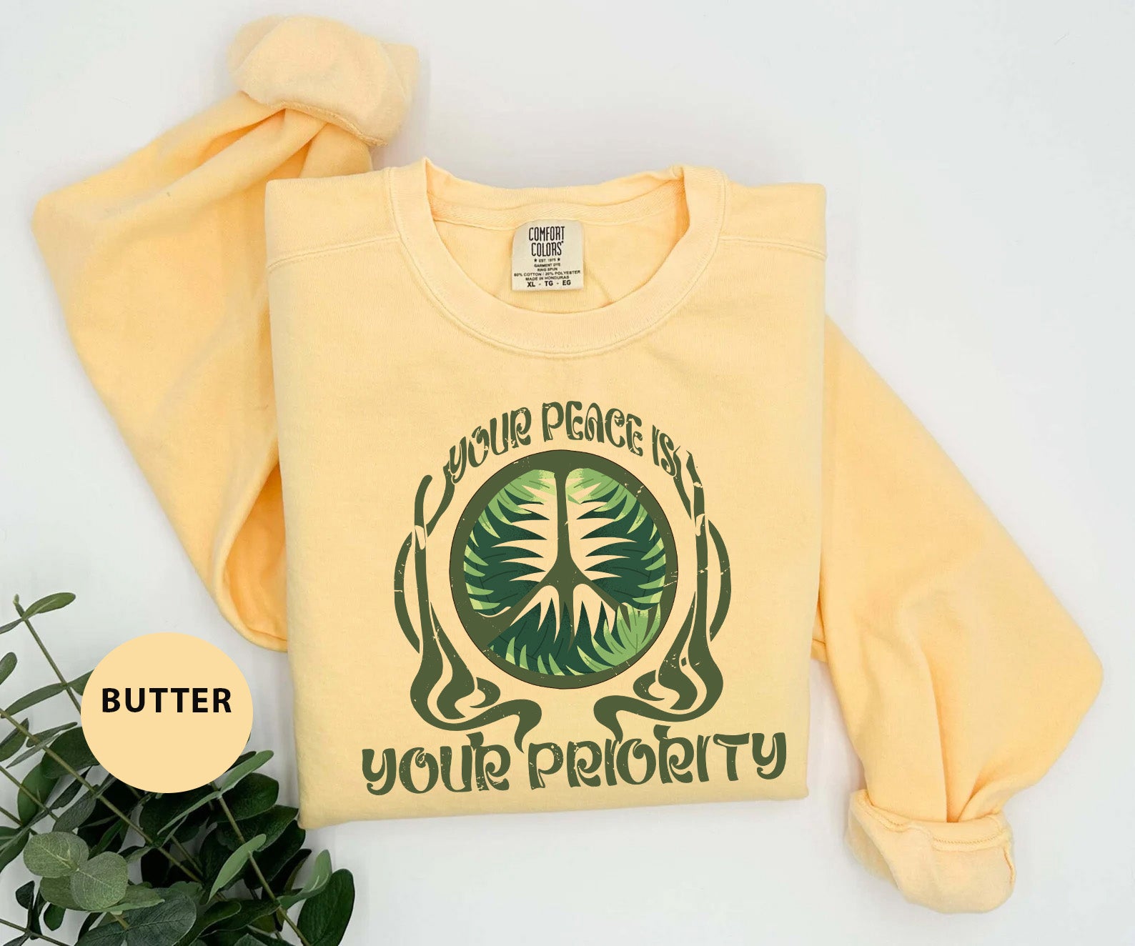 a yellow shirt with a green tree on it