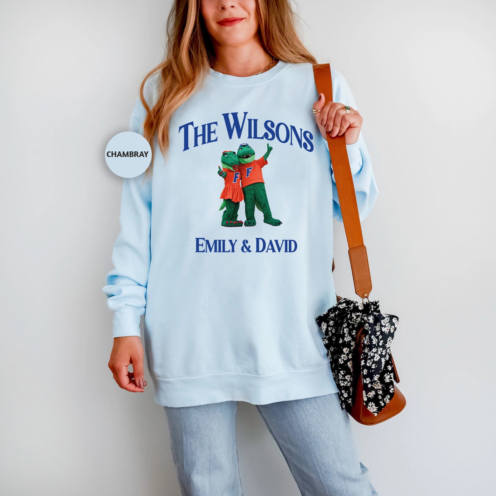 a woman in a blue sweatshirt holding a purse