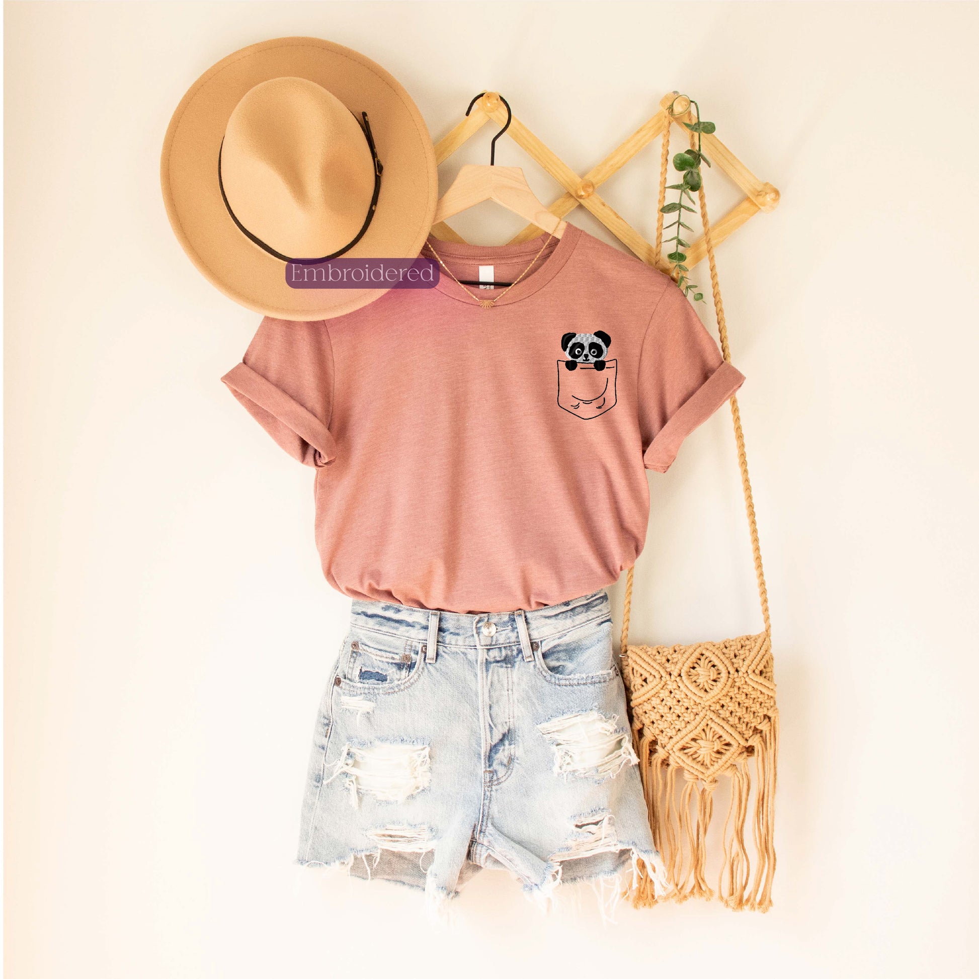 a hat, a t - shirt, and a straw bag are hanging on a