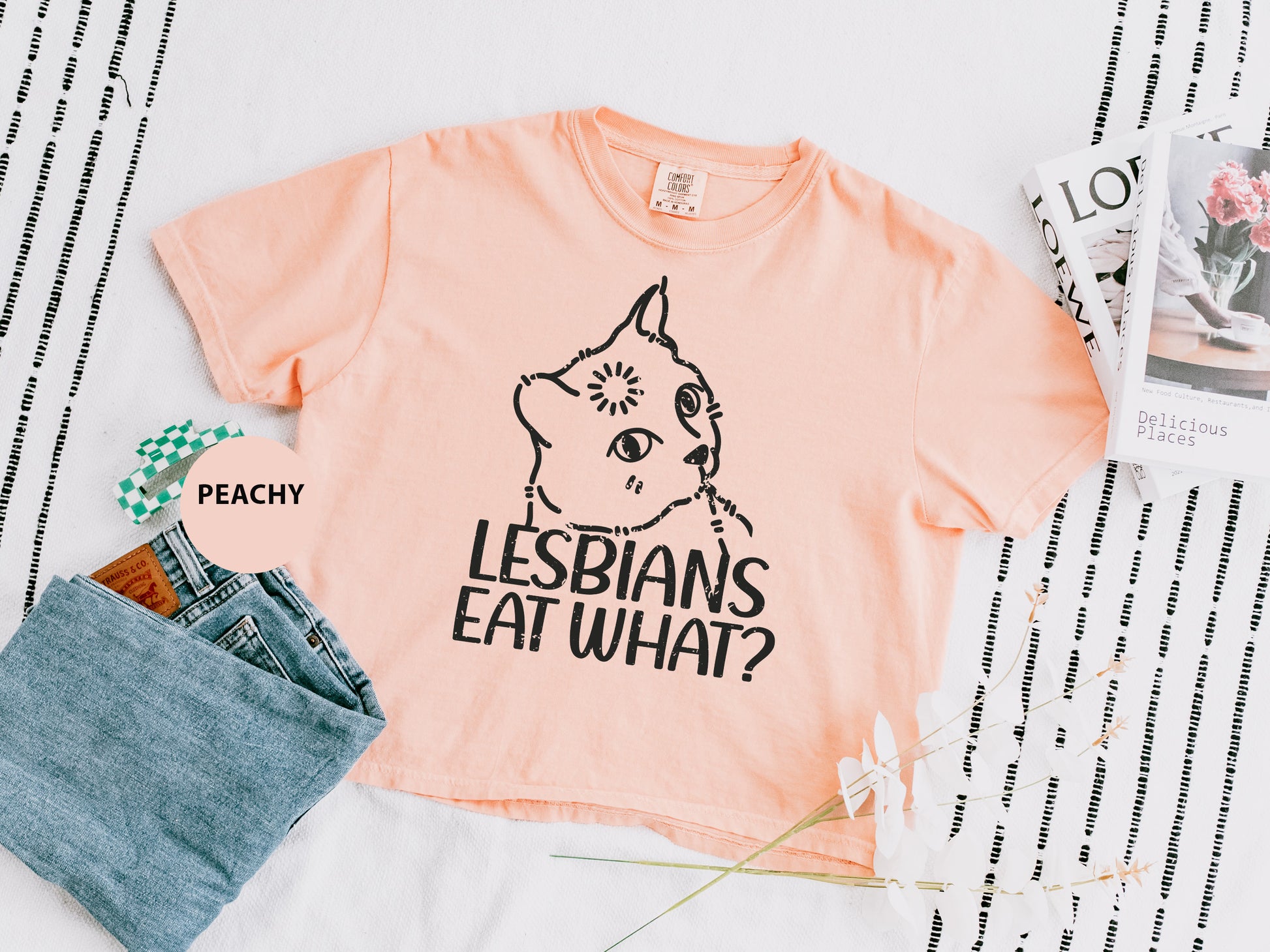 a t - shirt that says lesbians eat what? next to a pair of