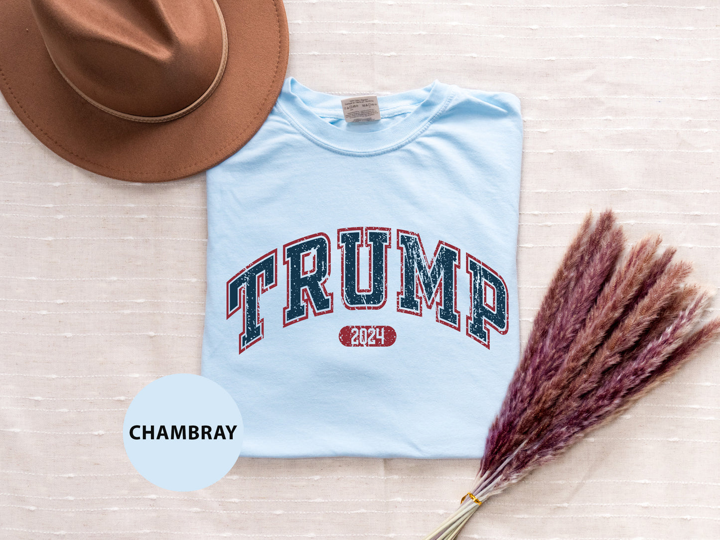 a t - shirt with the word trump on it next to a hat