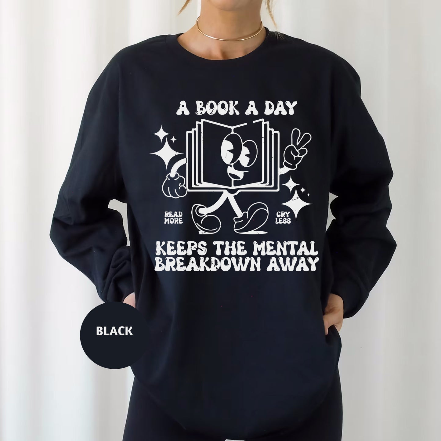 a woman wearing a black sweatshirt that says a book a day keeps the mental break