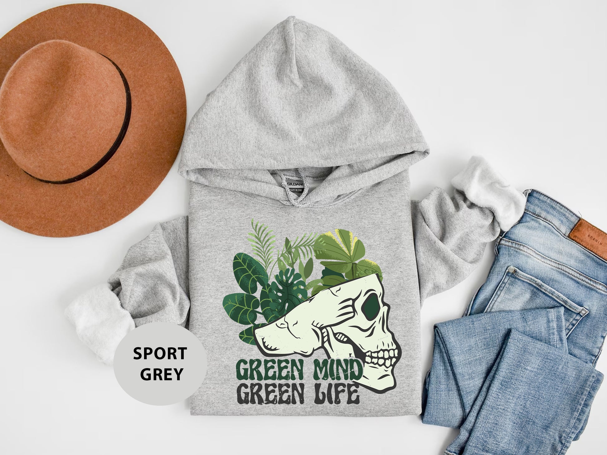 a gray hoodie with a green mind on it next to jeans and a hat