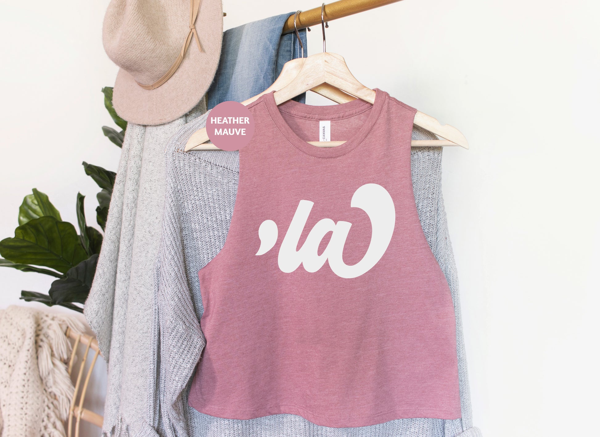 a t - shirt hanging on a clothes rack next to a hat