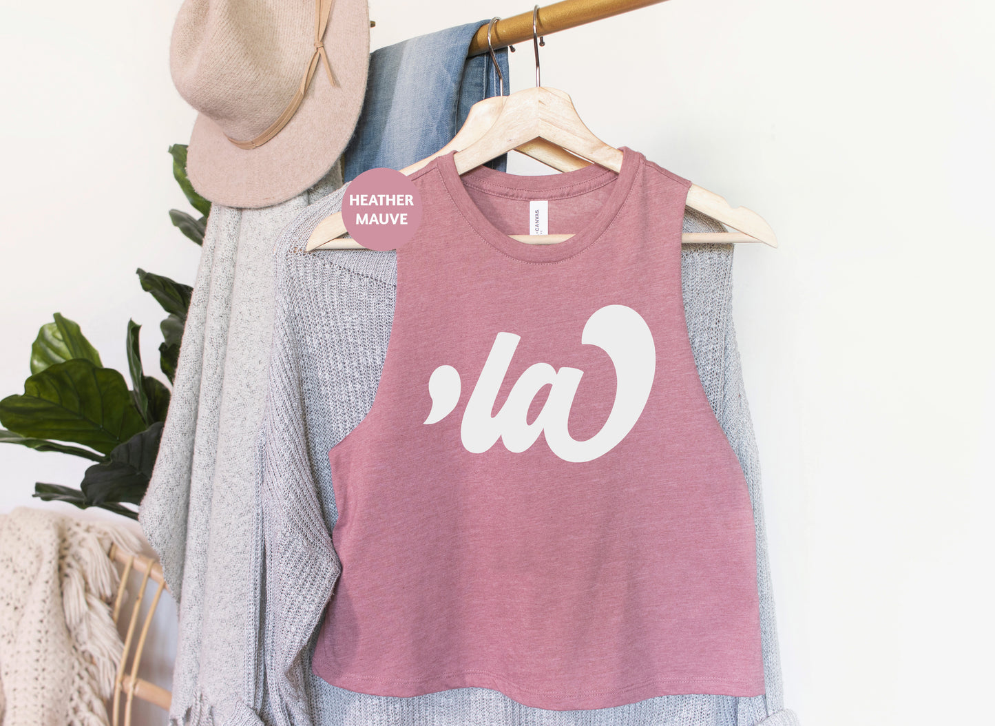 a t - shirt hanging on a clothes rack next to a hat