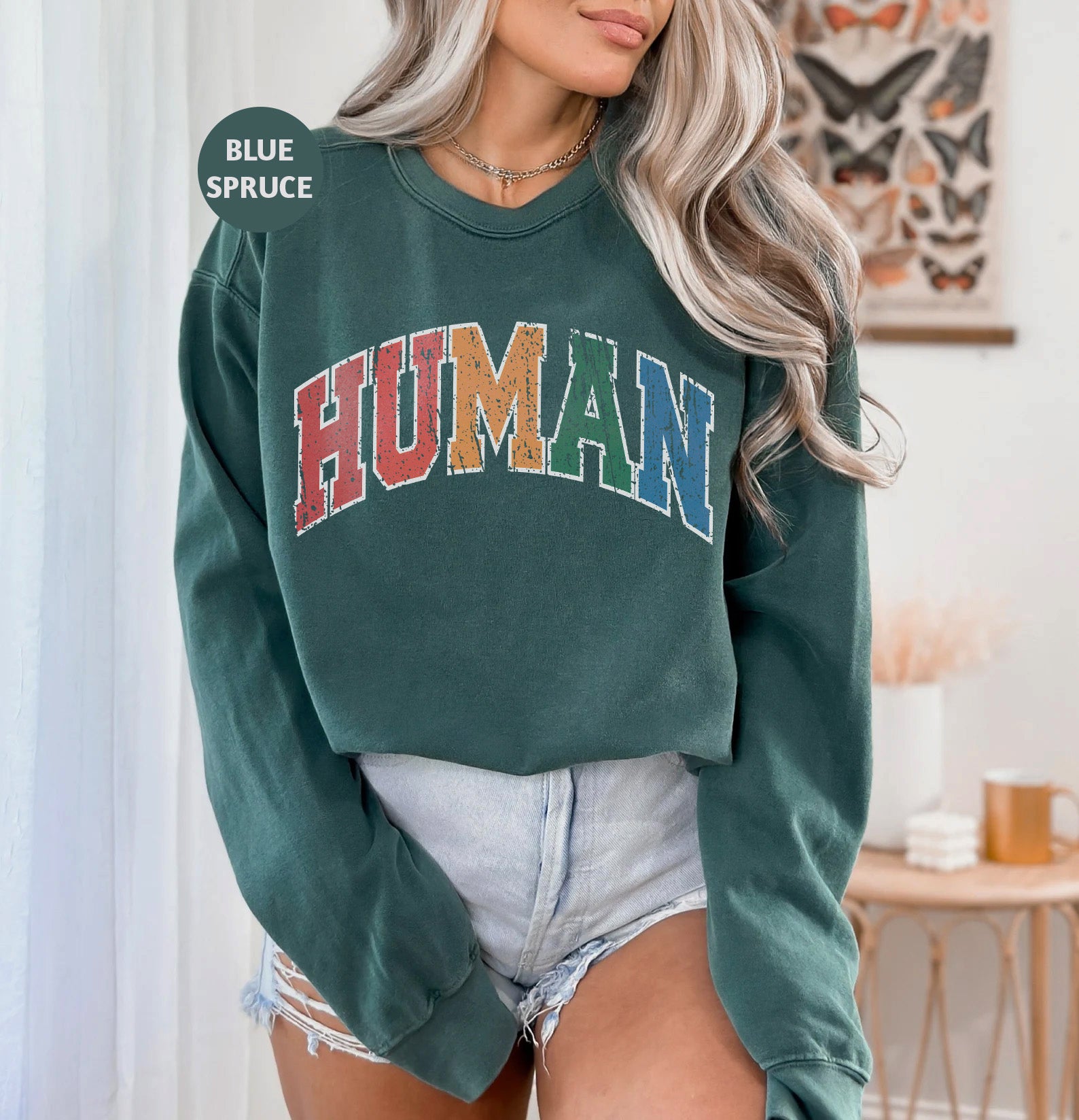 a woman wearing a green sweatshirt with the word human on it
