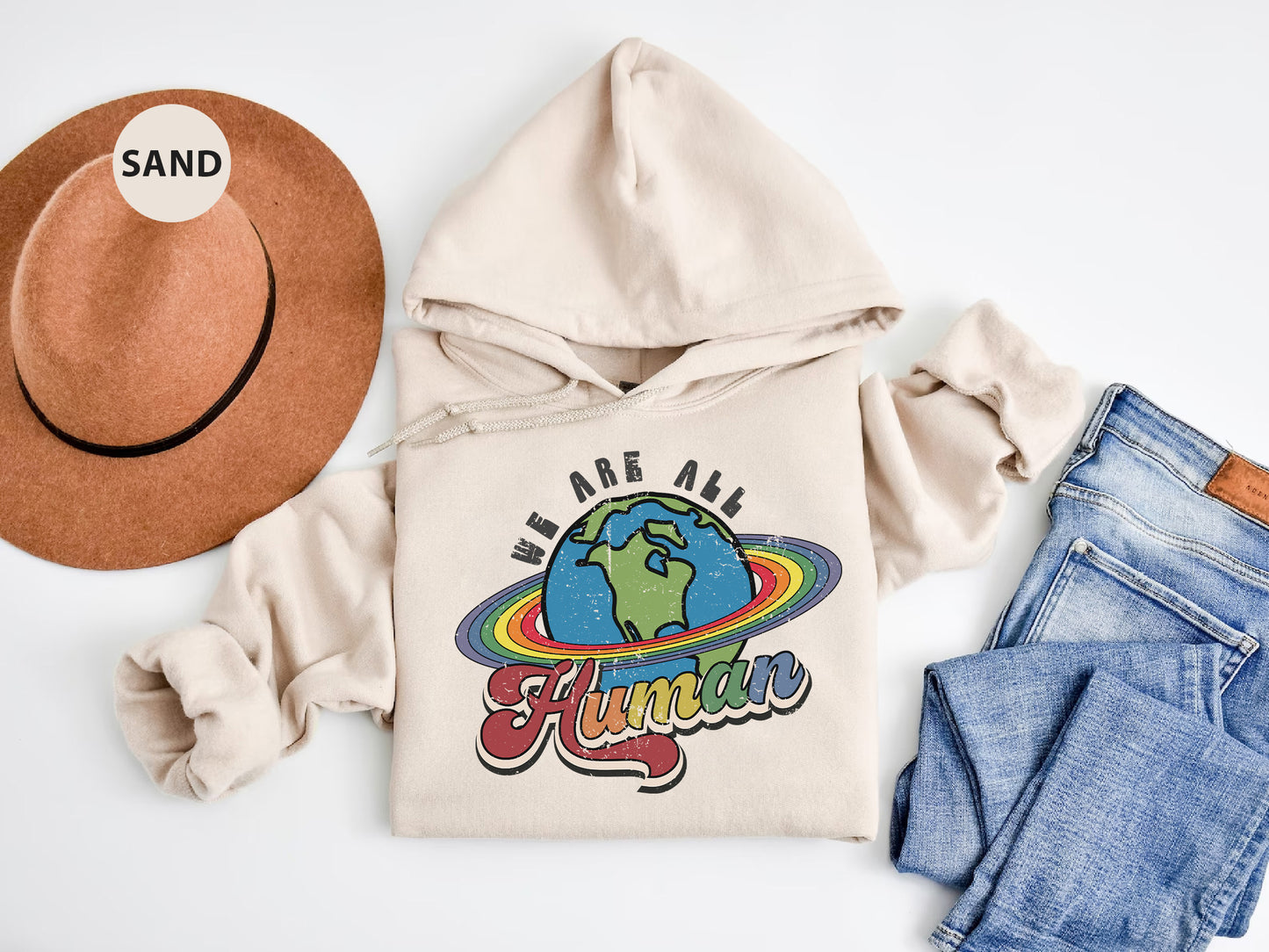 a hat, sweatshirt, jeans, and a pair of shoes on a white surface