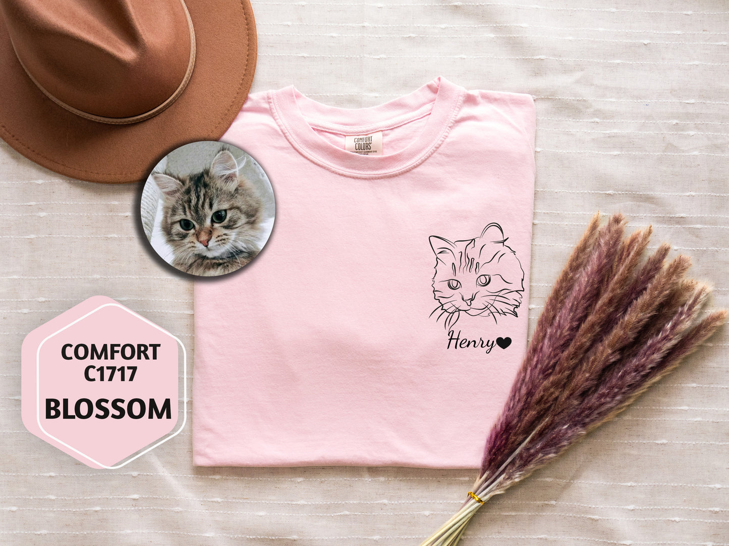 a pink t - shirt with a picture of a cat on it next to a