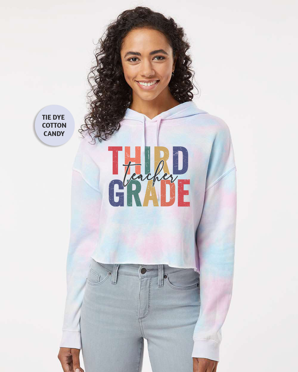 a woman wearing a tie dye hoodie that says third grade