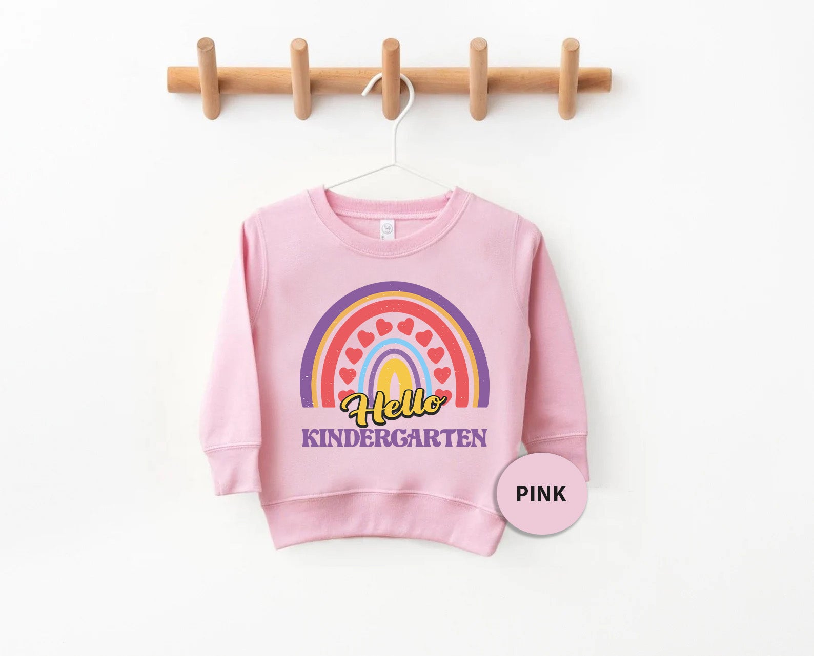 a pink sweatshirt hanging on a clothes rack