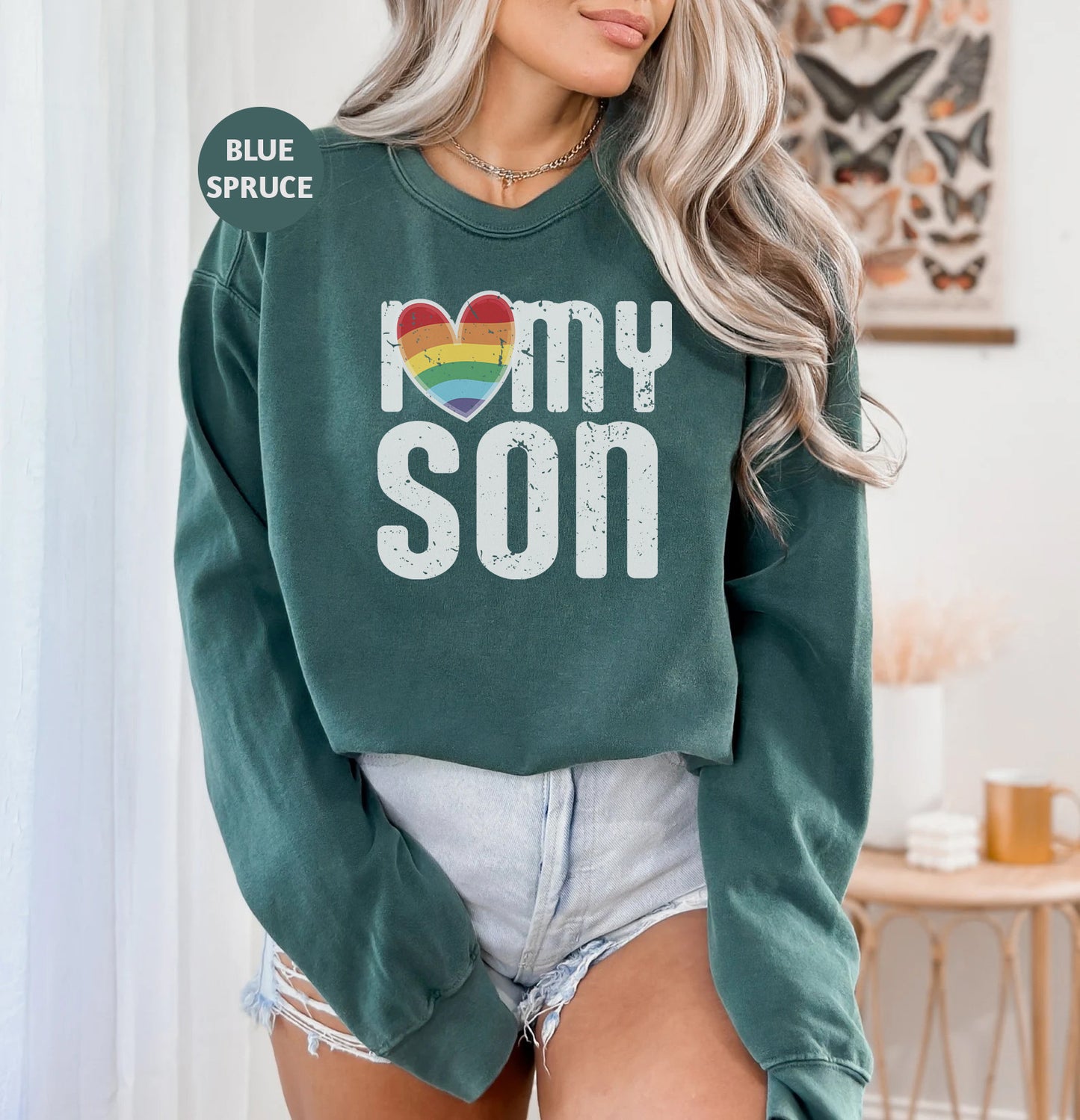 a woman wearing a green sweatshirt that says i love my son