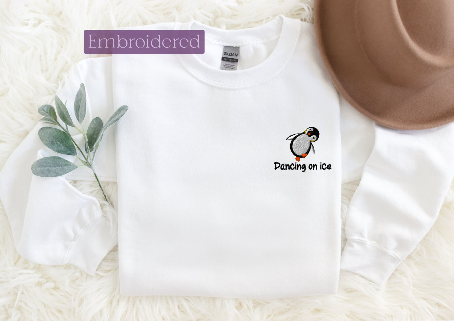 a white shirt with a penguin on it and a brown hat