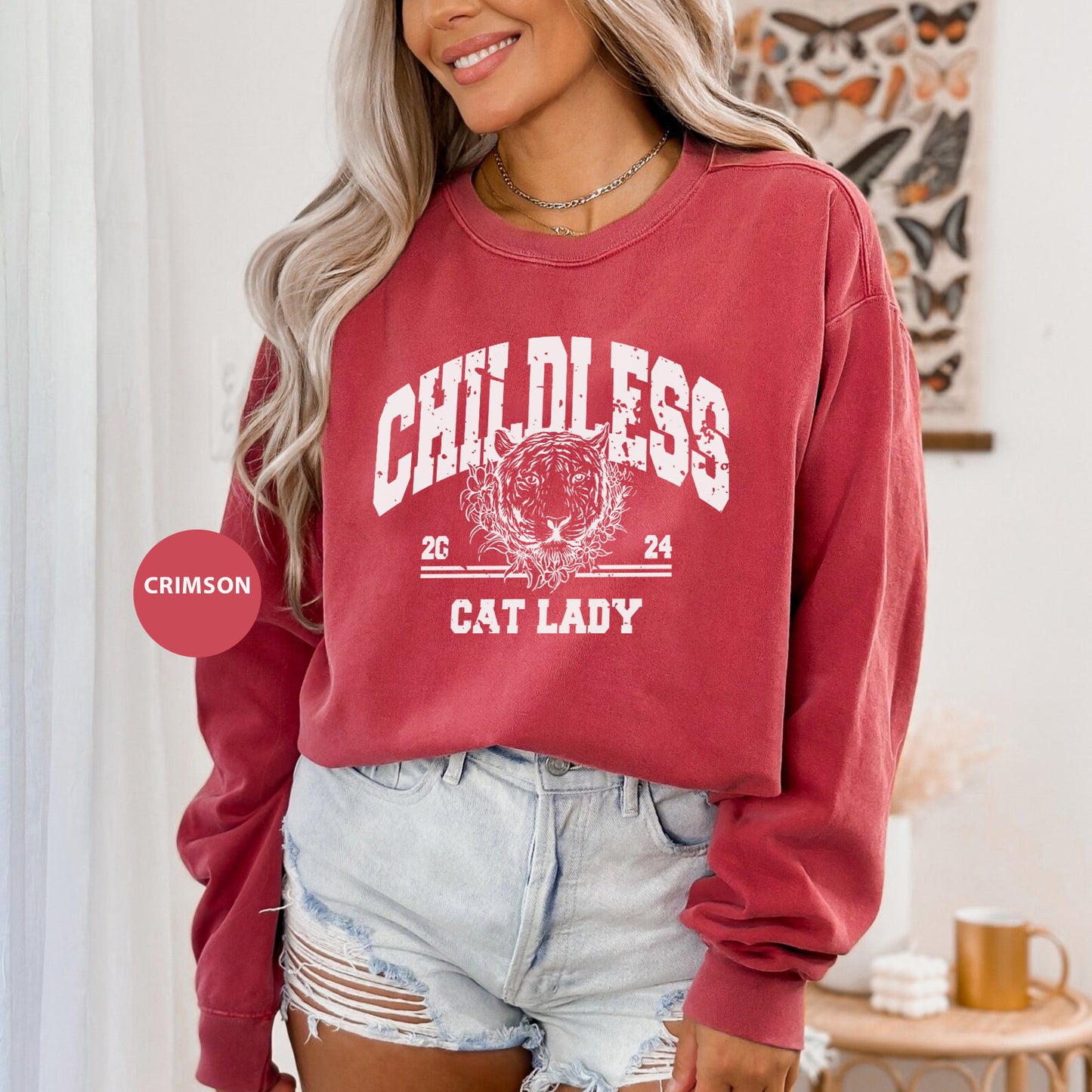 a woman wearing a red sweatshirt and denim shorts